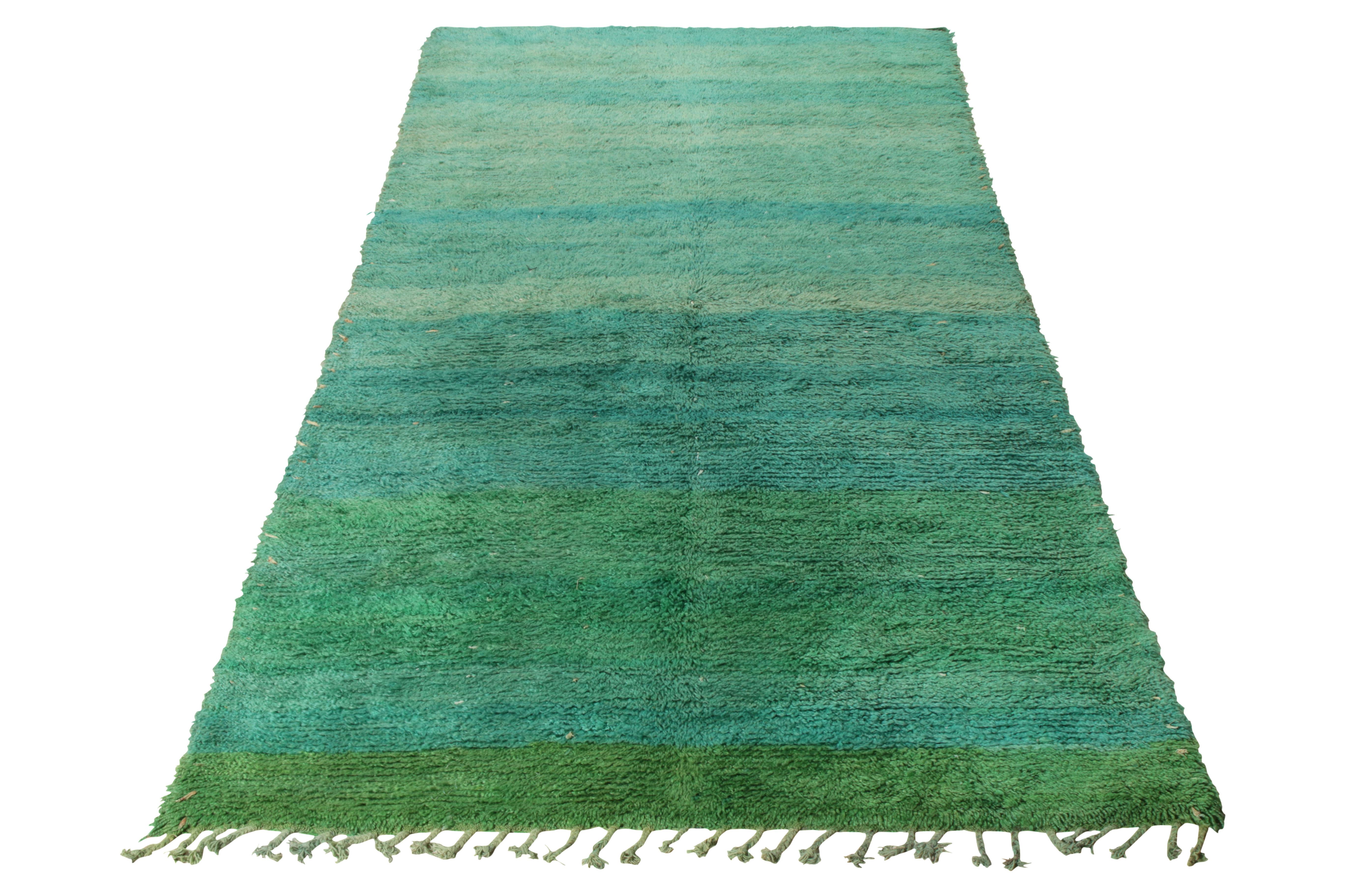 Noué à la main en laine, ce tapis marocain vintage datant des années 1950-1960 fait partie de la collection de Rug & Kilim. 

Tapis tribal berbère, ce tapis présente des franges unilatérales sur la bordure inférieure et une striation de couleurs
