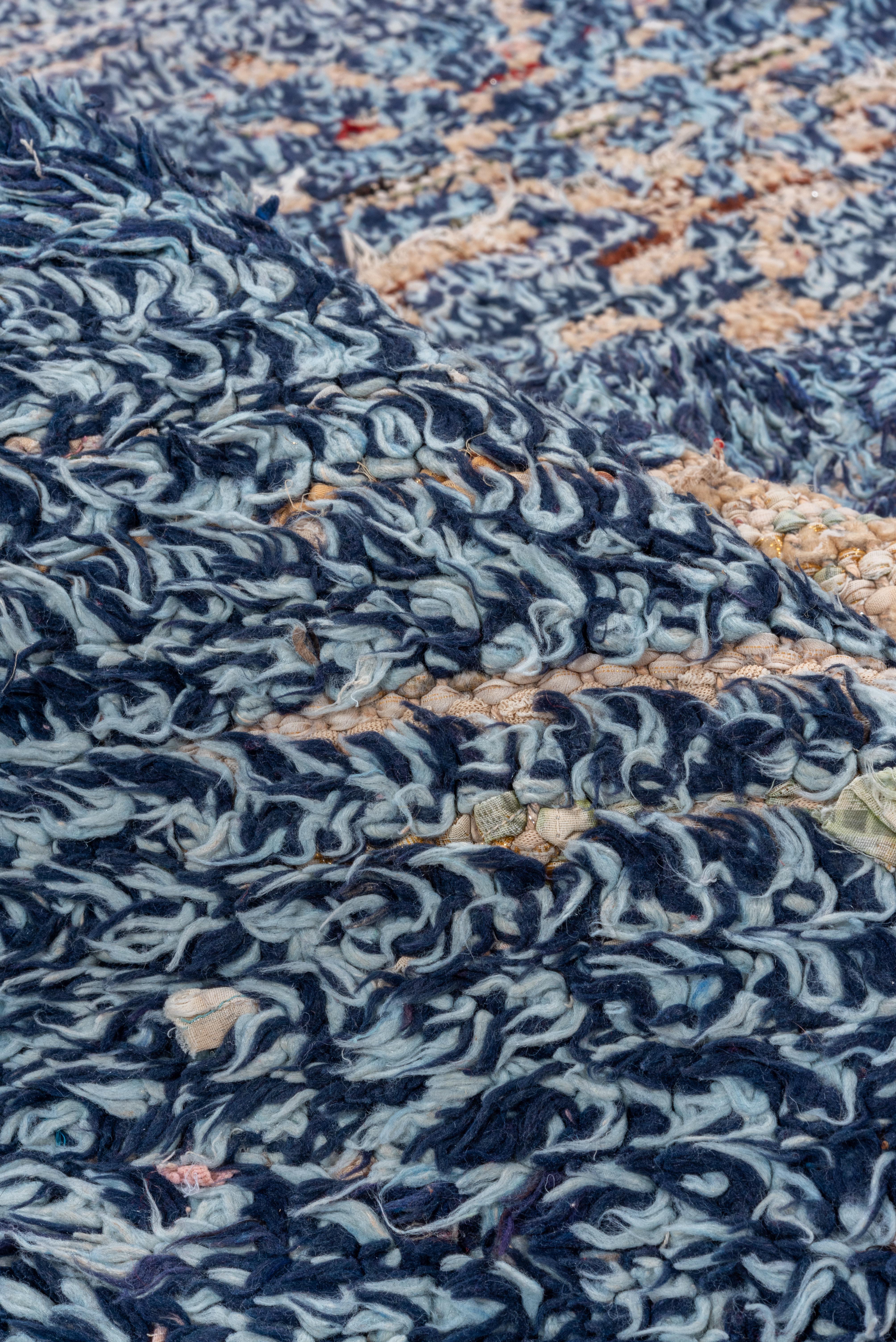 This vintage Moroccan rug is rendered in a rich indigo blue, showcasing a bold central arrangement of ivory diamond motifs framed by traditional Berber star symbols. The thick, shaggy wool pile lends a tactile softness and warmth, while the