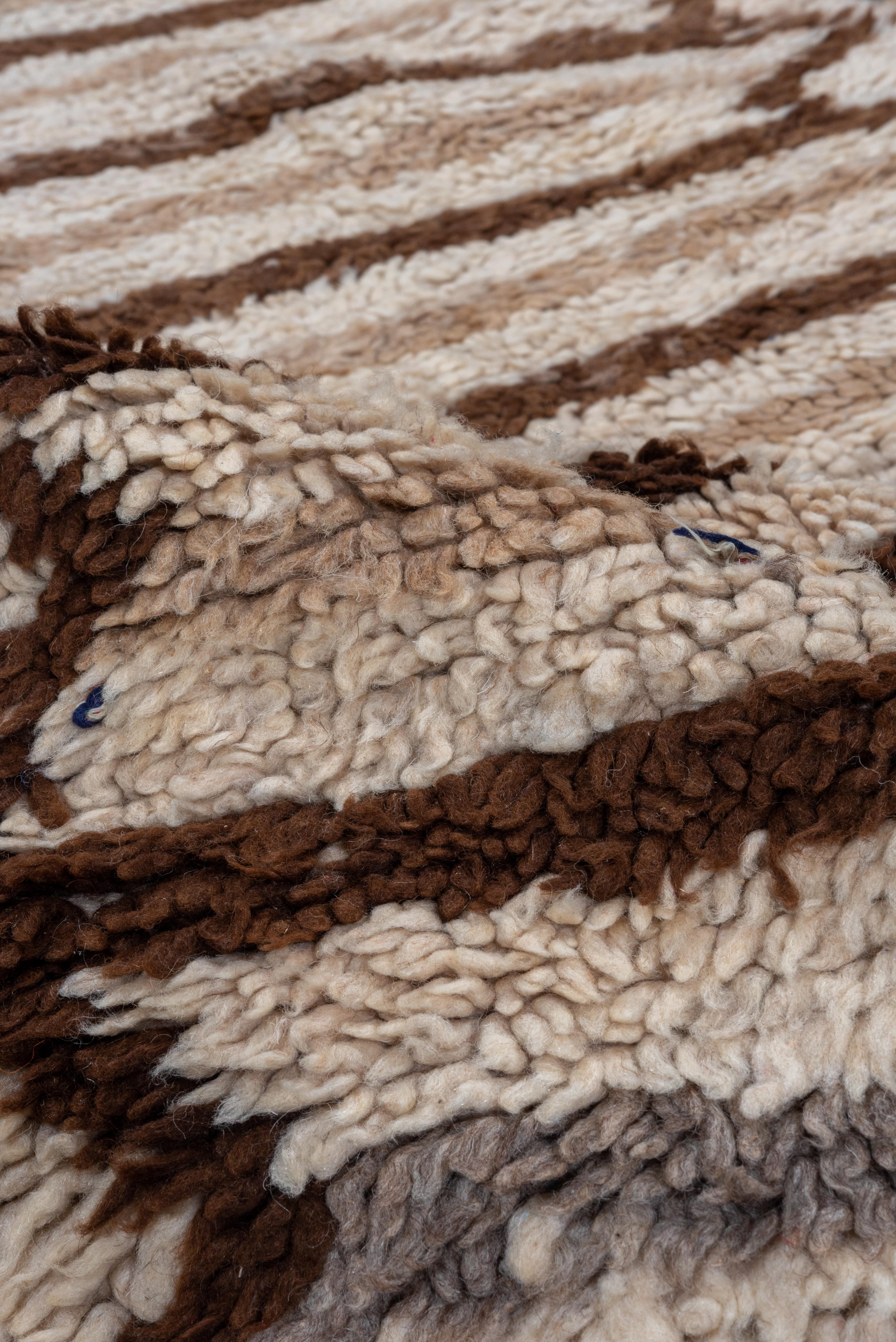 Esta alfombra marroquí vintage presenta un llamativo diseño lineal, con rítmicas rayas horizontales en marrón nogal oscuro sobre un suave fondo marfil. El estampado, sencillo pero impactante, ofrece una sensibilidad tribal moderna, basada en la