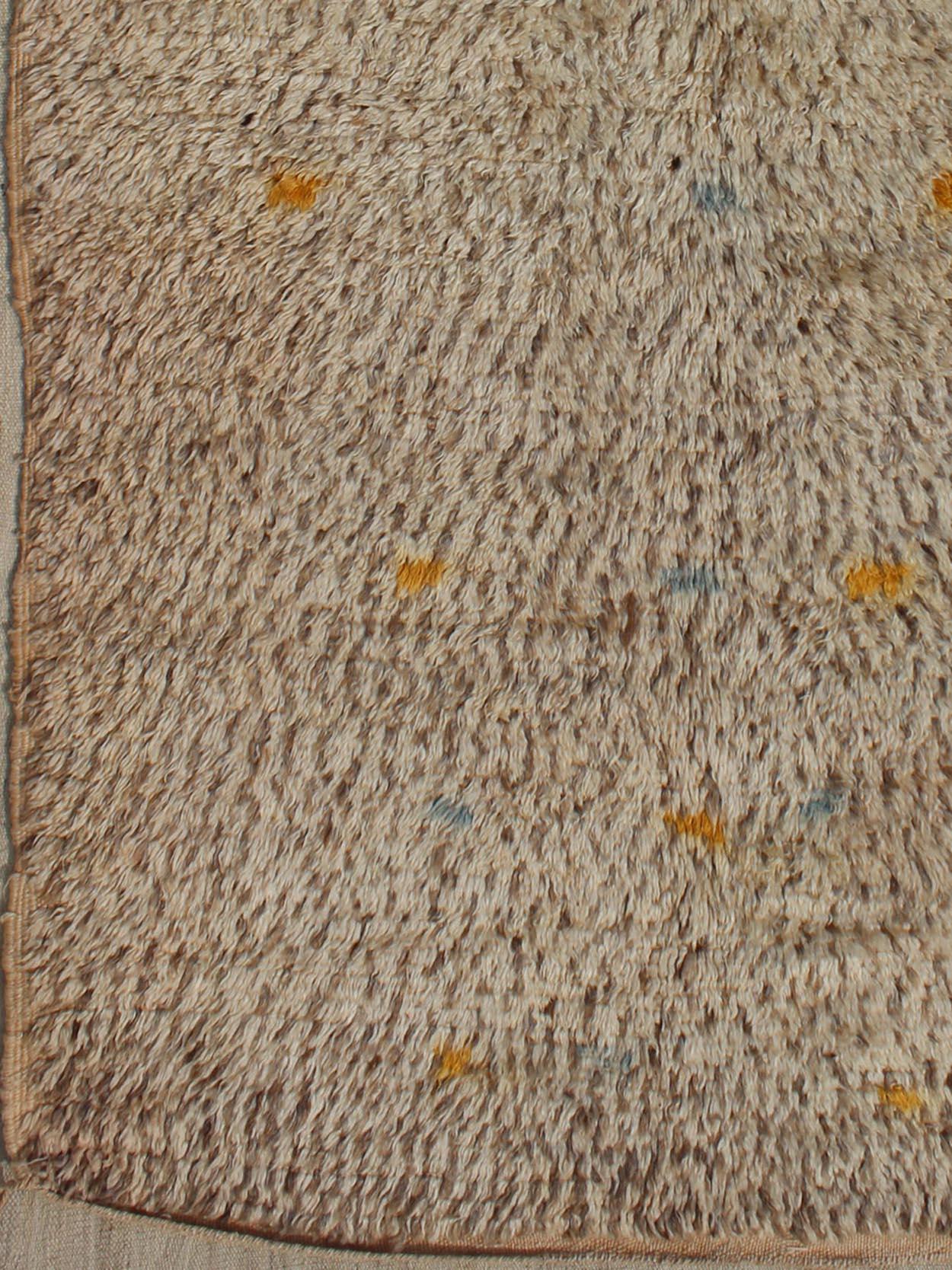 Vintage Moroccan rug on a taupe field with pops of blue and yellow.
Rug BDS-20124, Keivan Woven Arts / country of origin / type: Morocco / Tribal, circa 1940.
Measures: 4'0 x 6'6.
This unique vintage Moroccan carpet is characterized by a simple