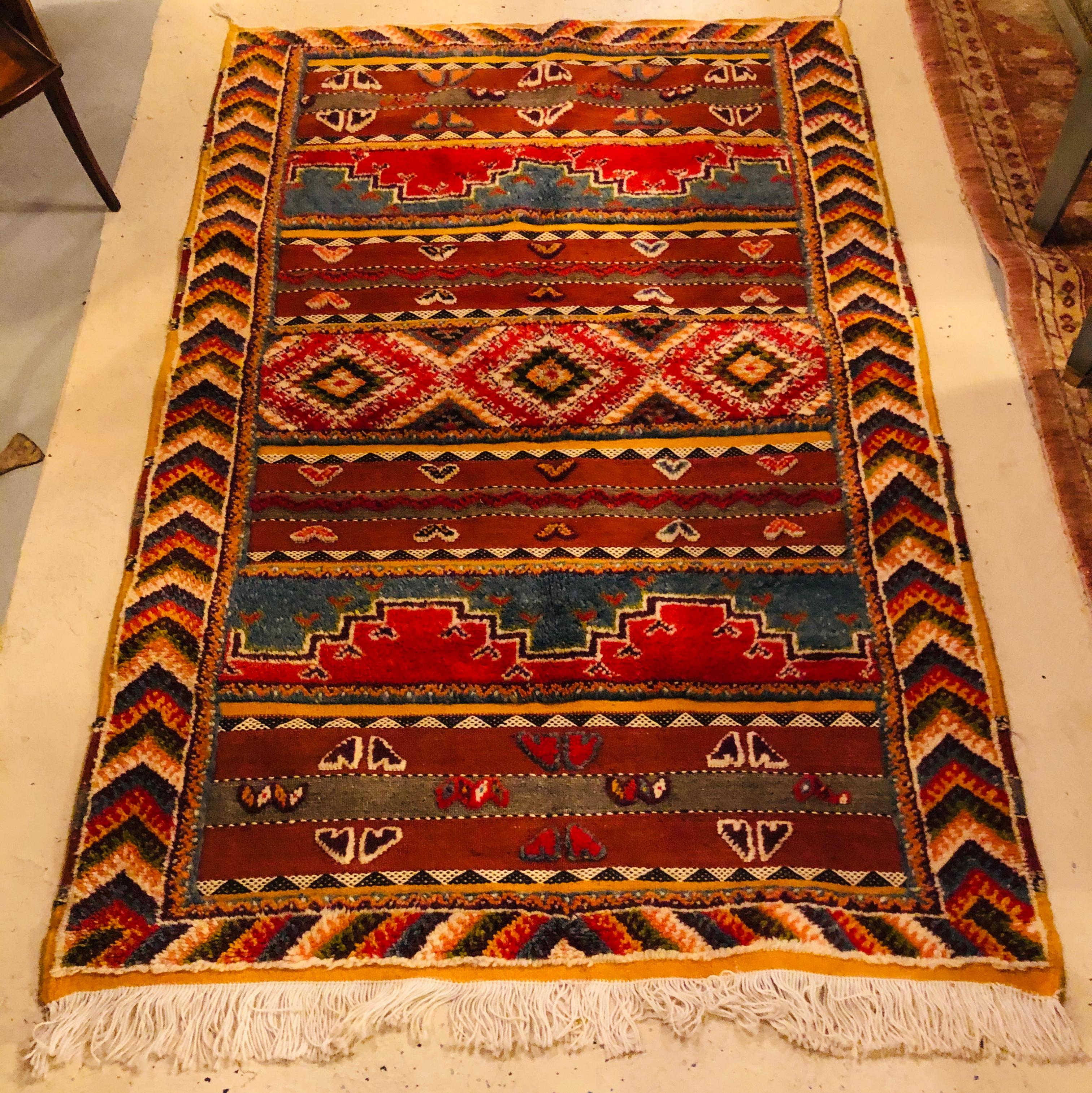 A beautiful and one of a kind vintage tribal rug in earthy tone colors and tribal motifs and designs reflecting over a thousand year culture. The rug handwoven by tribal women in the Atlas mountains features central diamond pattern with complex and