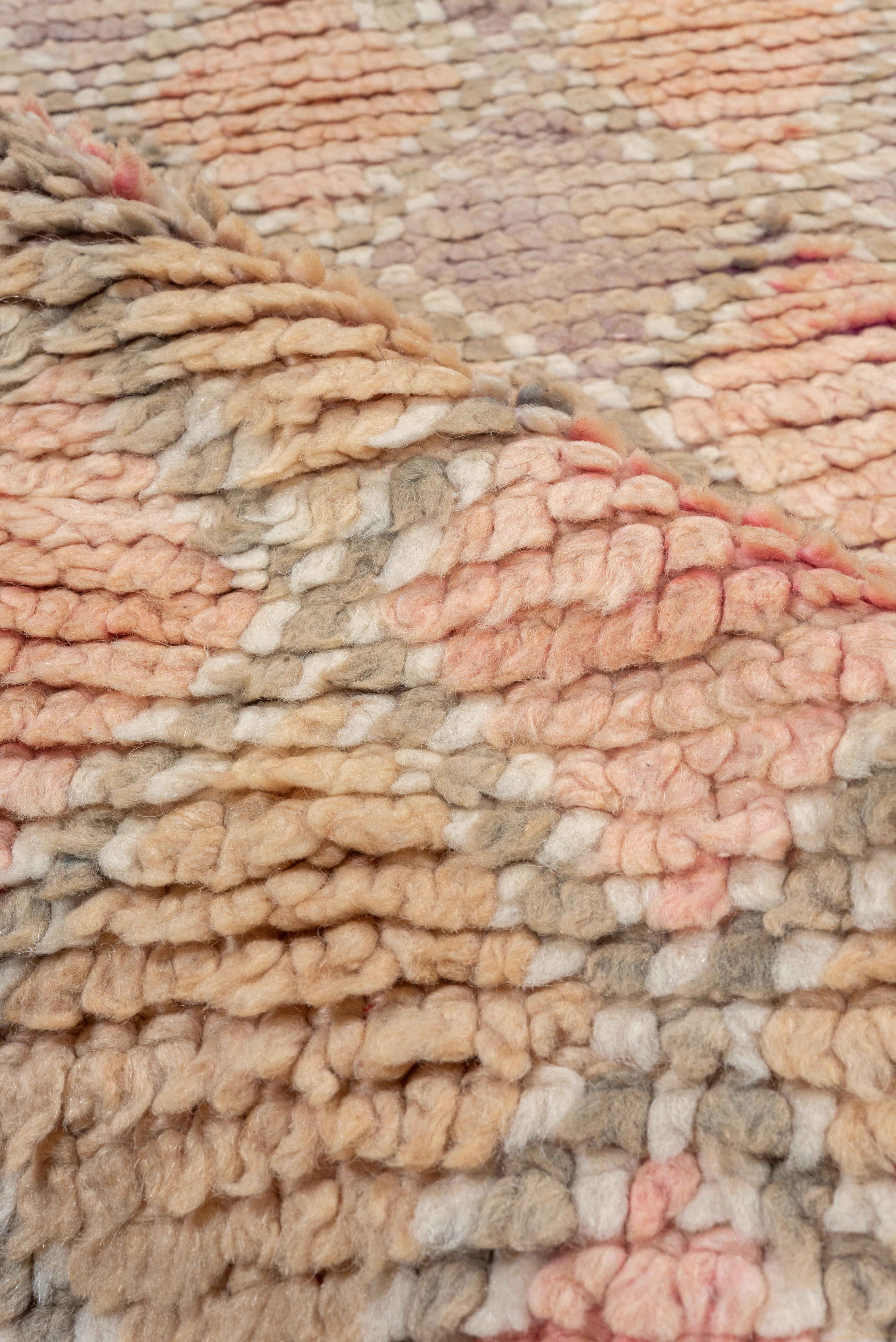 Esta alfombra marroquí vintage presenta una delicada transición ombré del rosa arena al ciruela intenso, enriquecida por un suave entramado de rombos que intensifica gradualmente el tono de abajo a arriba. La composición finamente tejida captura un