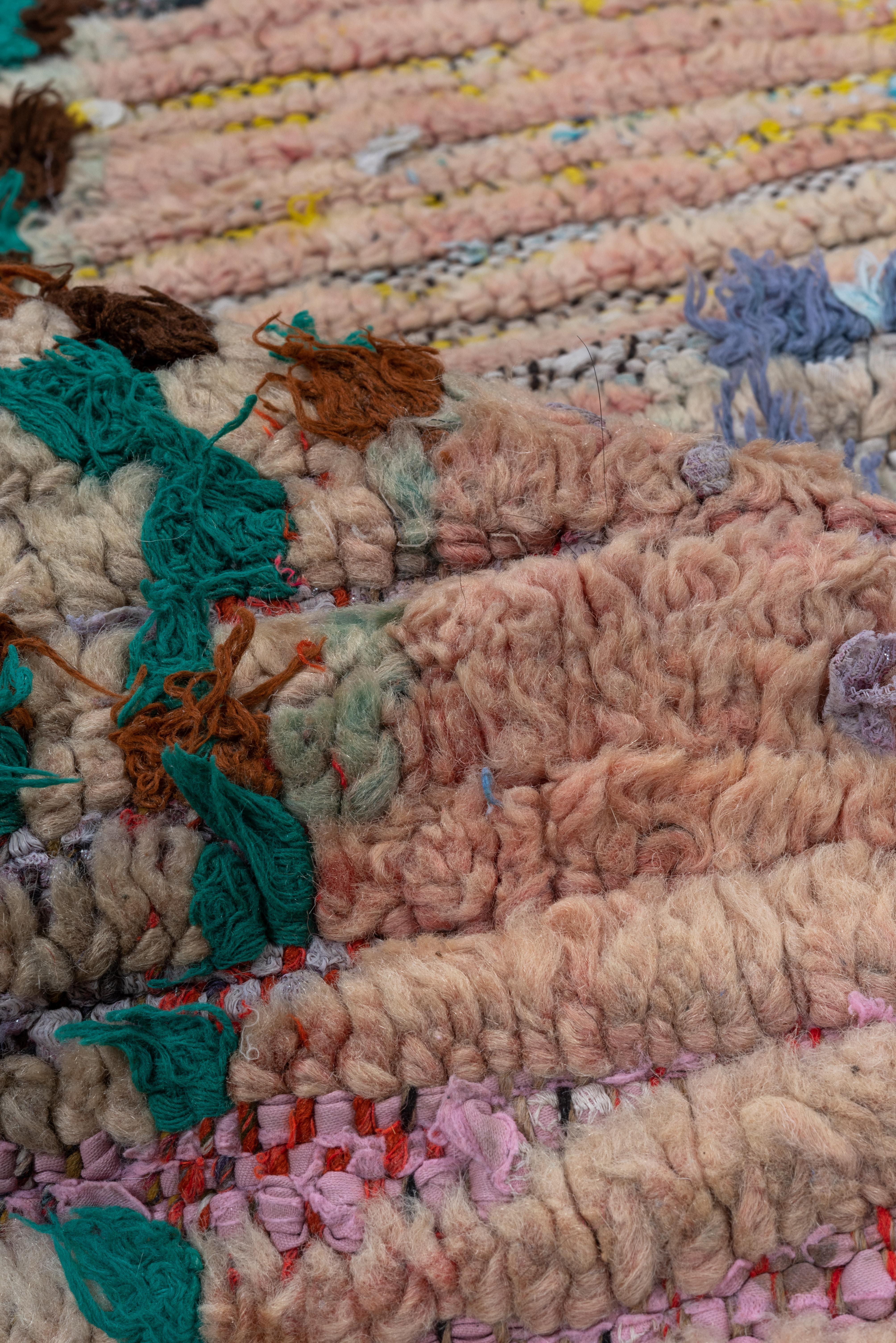 Esta alfombra marroquí vintage irradia individualidad por su distintiva disposición de motivos tribales sobre un suave campo rubor. Los atrevidos emblemas abstractos en turquesa, esmeralda, negro y castaño evocan la narración simbólica propia del