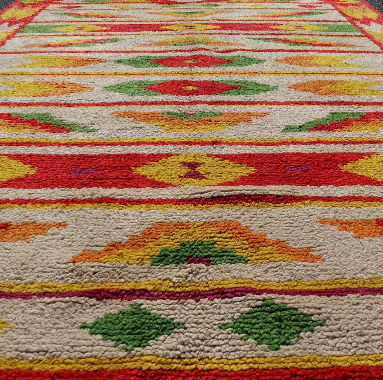 Tapis marocain vintage à motifs tribaux en rouge, vert et jaune. Keivan Woven Arts / tapis W22-1200, pays d'origine / type : Maroc / Tribal, circa mid-20th century.
Mesures : 5'10 x 8'11 
Ce tapis marocain présente un motif géométrique sur fond