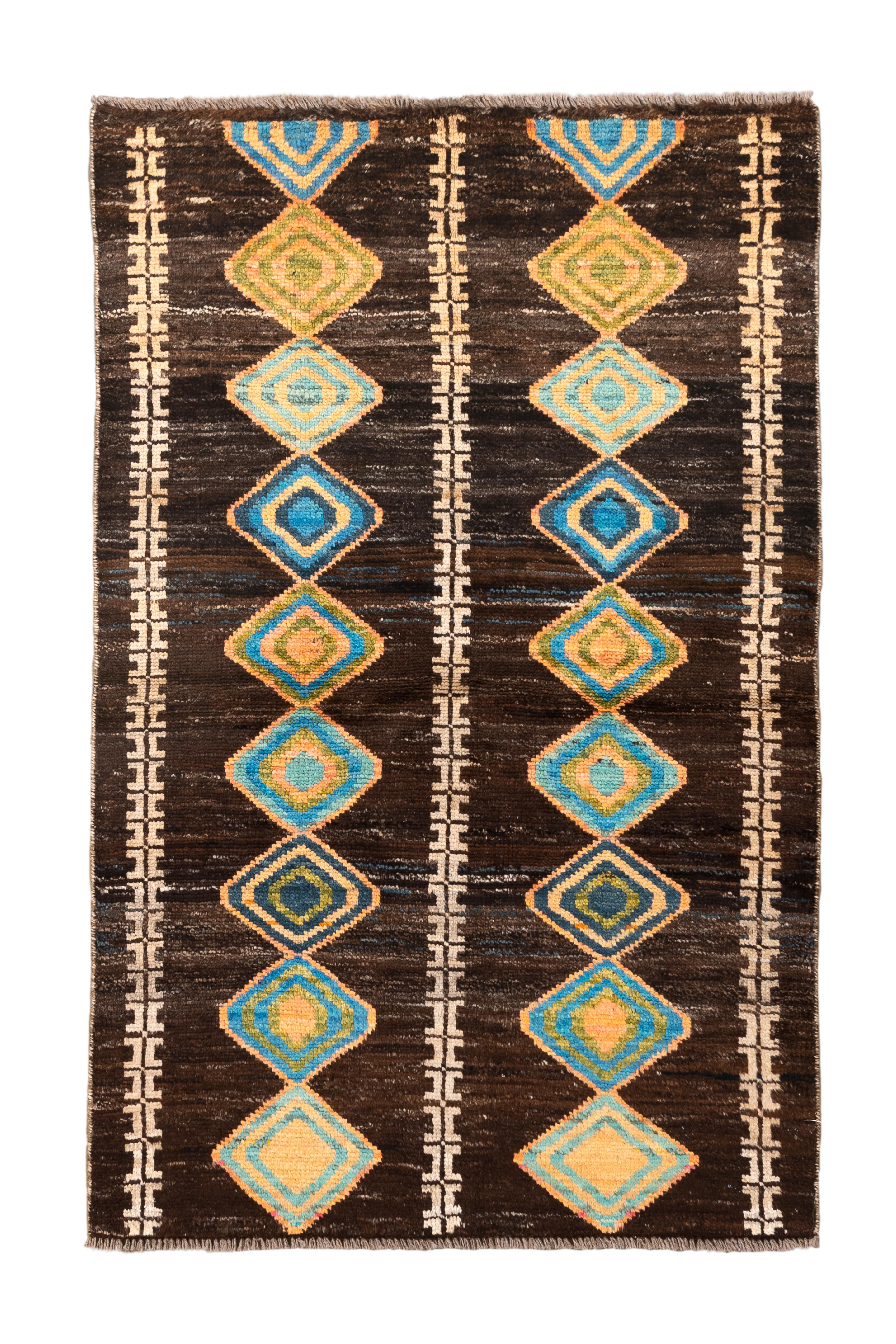  A vibrant vintage Moroccan rug featuring a rhythmic cascade of diamond-shaped medallions in turquoise, green, ochre, and sky blue, arranged in three vertical rows over a rich, dark espresso brown field. Flanked by tribal-inspired ivory guard