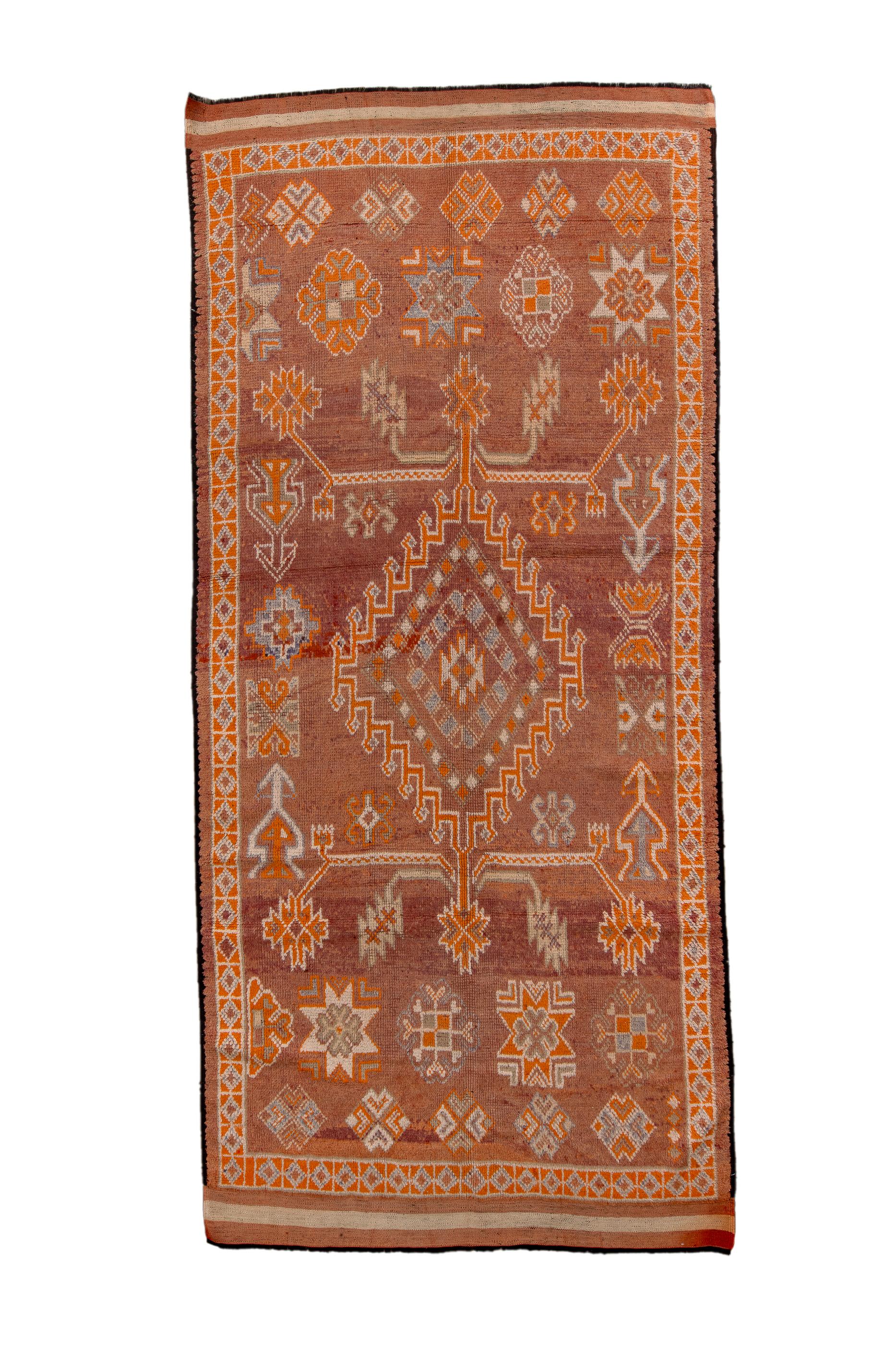 The rust madder field shows a stepped and fringed medallion bracketed by leafy branches, and surrounded by various eight point stars, and four blossom motives, all taken from Turkish village rugs.  Main narrow ivory border of squares with diamonds