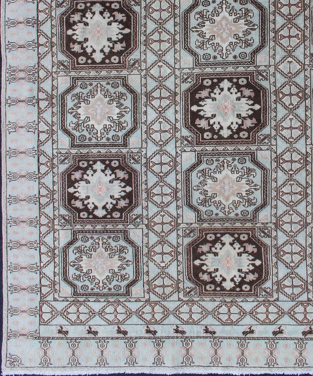 Alfombra marroquí con diseño de medallón, alfombra 13-0904, país de origen / tipo: Marruecos / Tribal, hacia mediados del siglo XX.

Medidas: 6'8 x 9'1.

Esta alfombra marroquí presenta un diseño de medallón repetido en tonos azul hielo y marrón