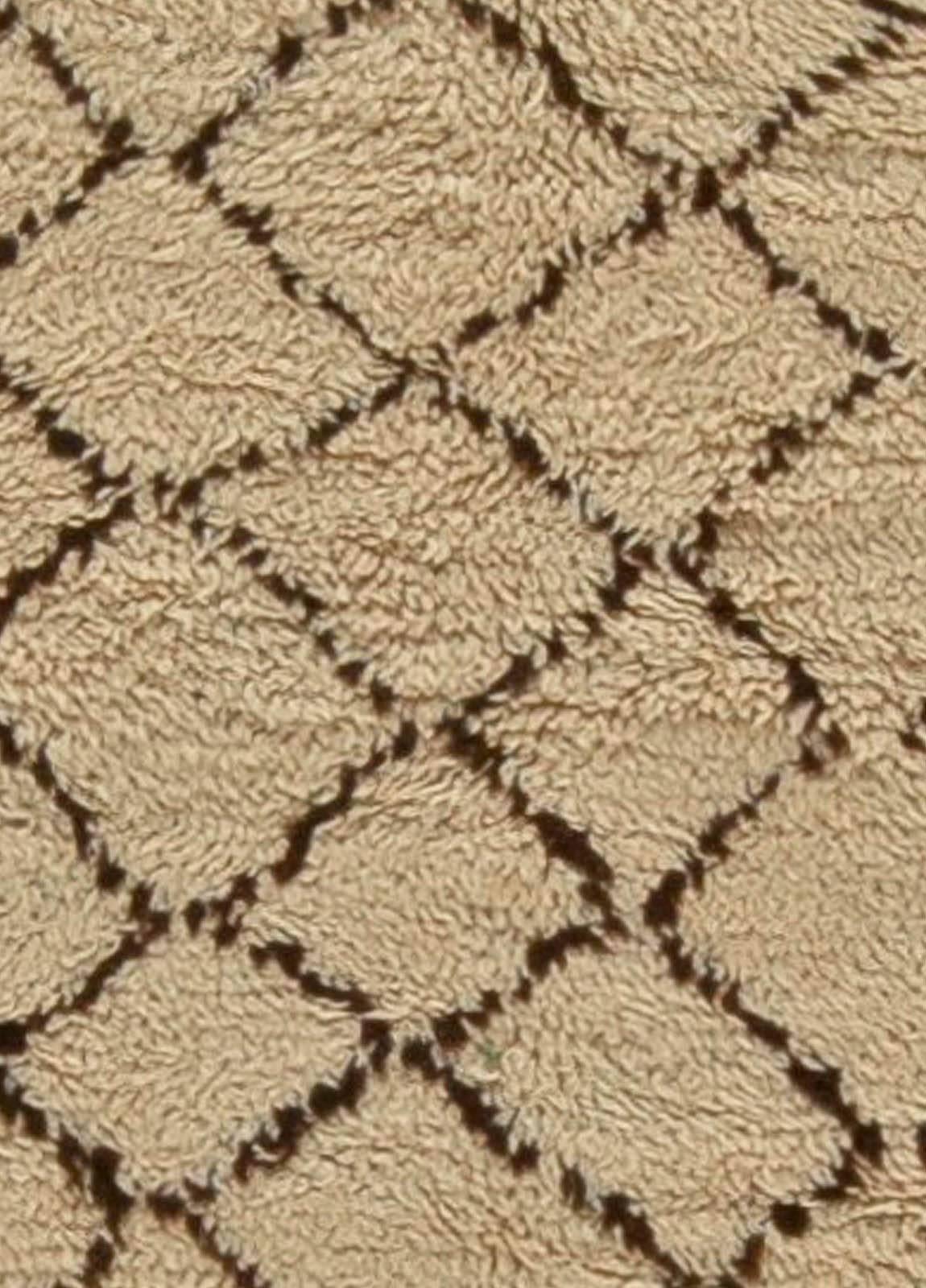 This vintage Moroccan runner rug features an all-over design of a brown lattice against a field of neutral beige, circa 1940. Stark and Minimalist, the vintage carpet is an intriguing abstract statement. Moroccan rugs have typically been woven by