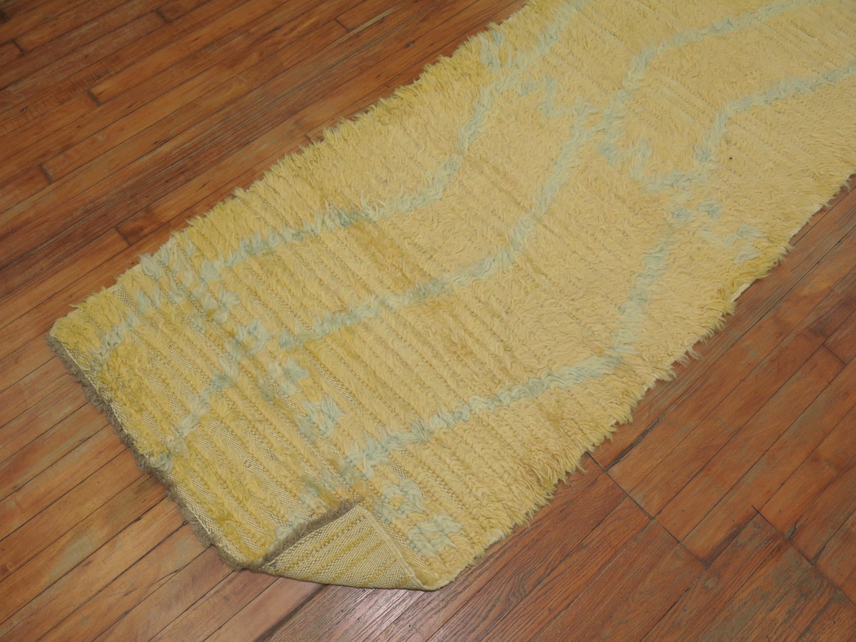 A mid-20th century handwoven Moroccan rug in gold and aqua blue.

2'9'' x 10'