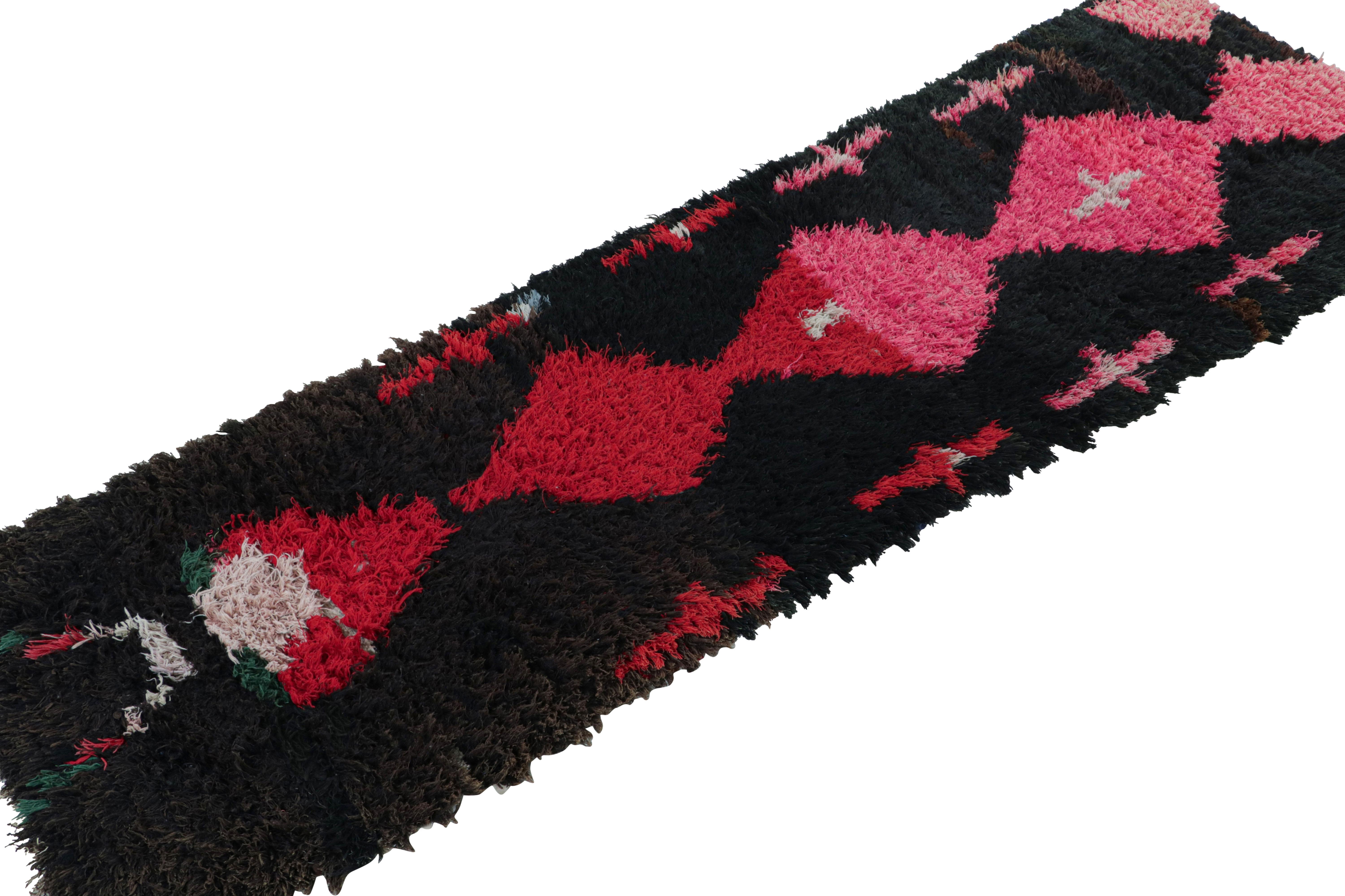 Hand-knotted in wool circa 1950-1960, this 2x8 vintage Moroccan runner rug with diamond medallions on a black field, hails from the Azilal tribe.  

On the Design: 

This piece enjoys a lush high pile with primitivist Berber geometric diamond