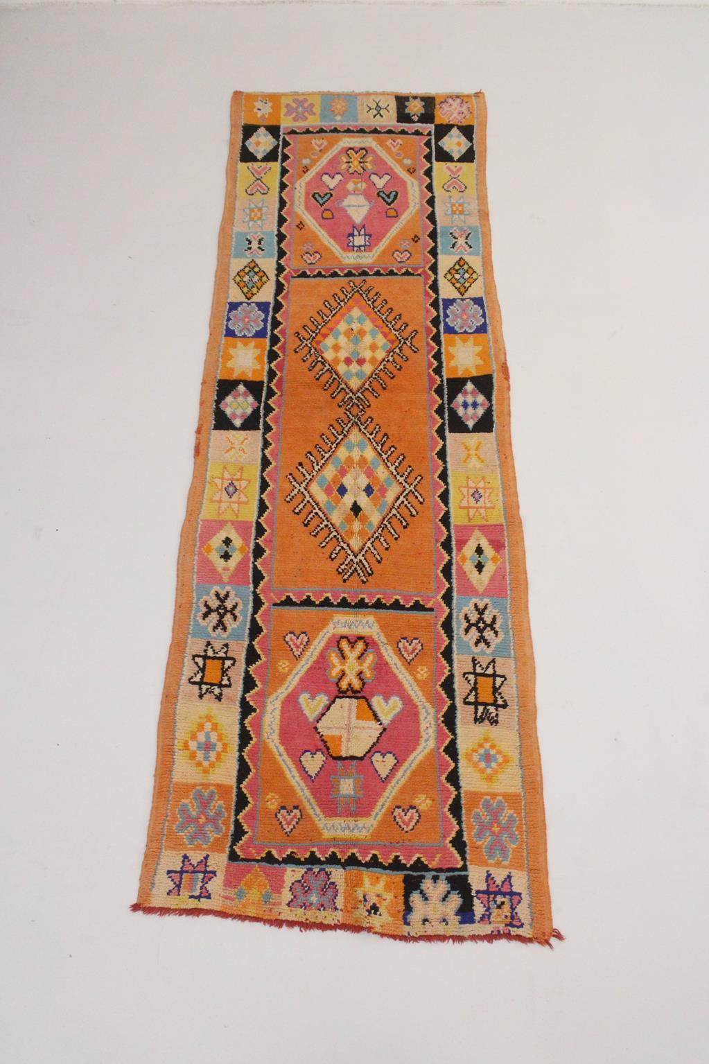 This long runner rug is such a sweet piece! Probably made in the area of Boujad, Middle Atlas, Morocco, the rug shows a classic serie of 4 large diamonds surrounded with multiple, smaller designs (crosses and stars) in tiny 