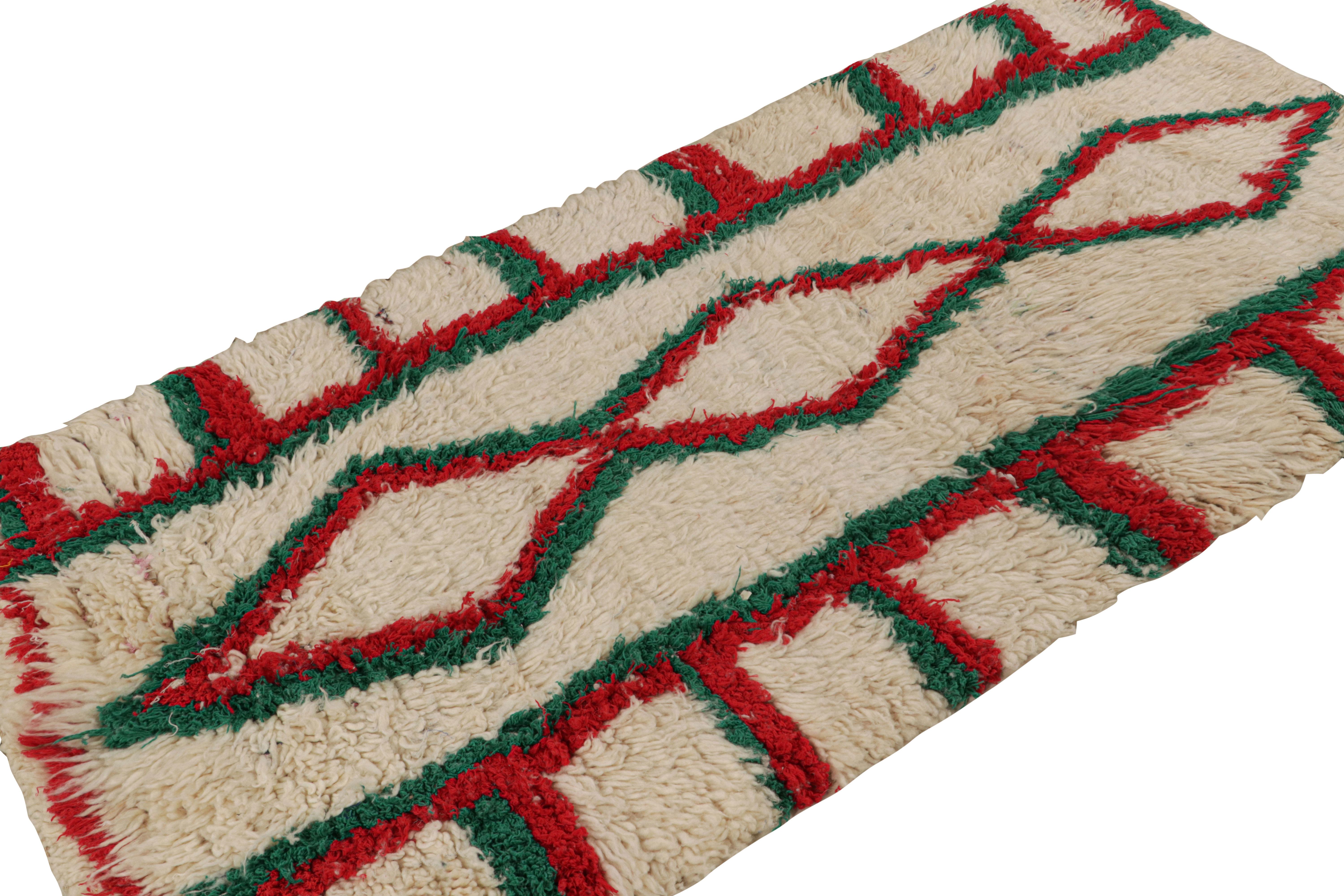 Hand-knotted in wool circa 1950-1960, this 3x7 vintage Moroccan runner rug with geometric patterns in red and green, hails from the Azilal tribe.  

On the Design: 

This piece enjoys a lush high pile with primitivist Berber geometric patterns in