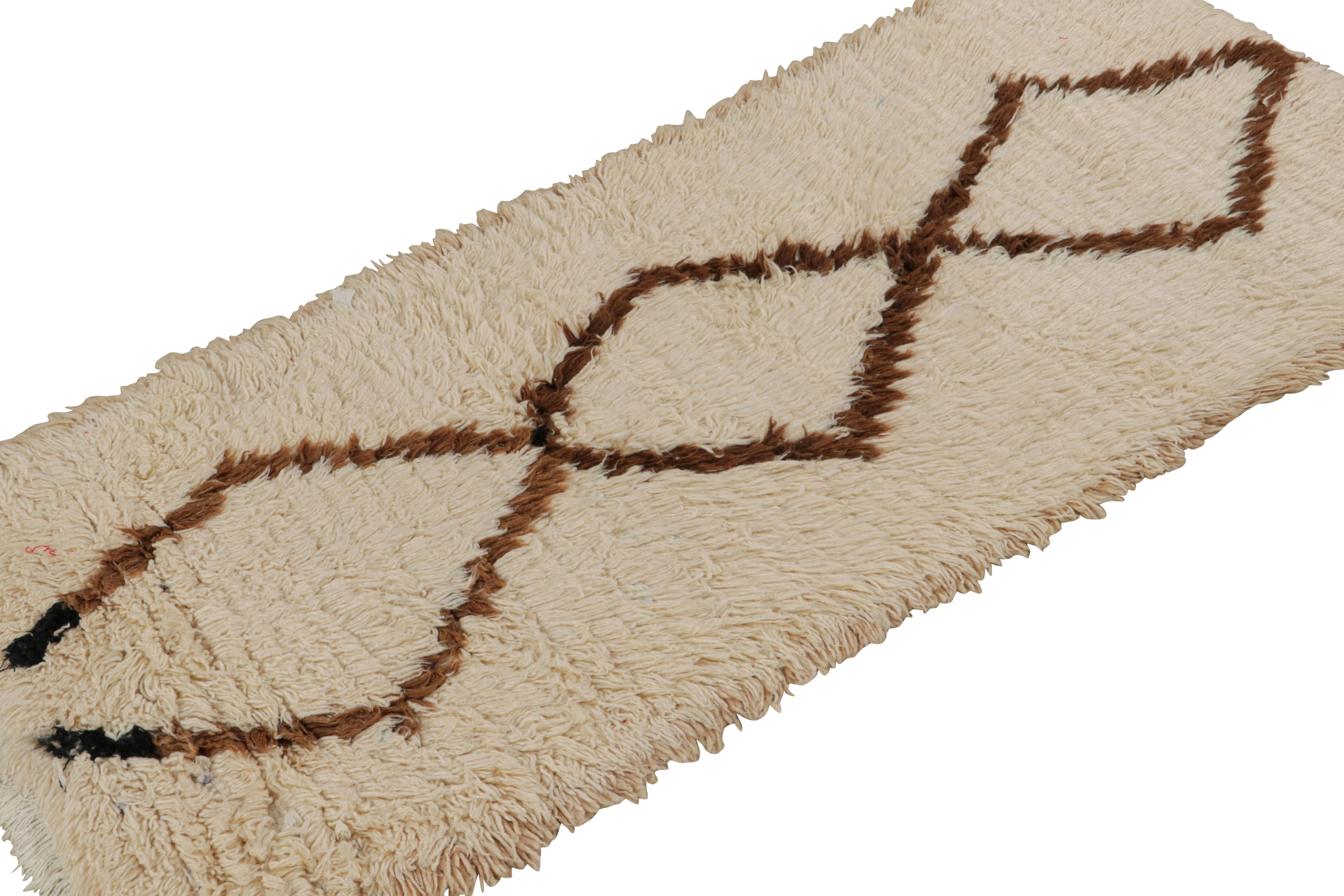 Hand-knotted in wool circa 1950-1960, this 2x6 vintage Moroccan runner rug in beige-brown with diamond medallions, hails from the Azilal tribe.  

On the Design: 

This piece enjoys a lush high pile with primitivist Berber geometric diamond