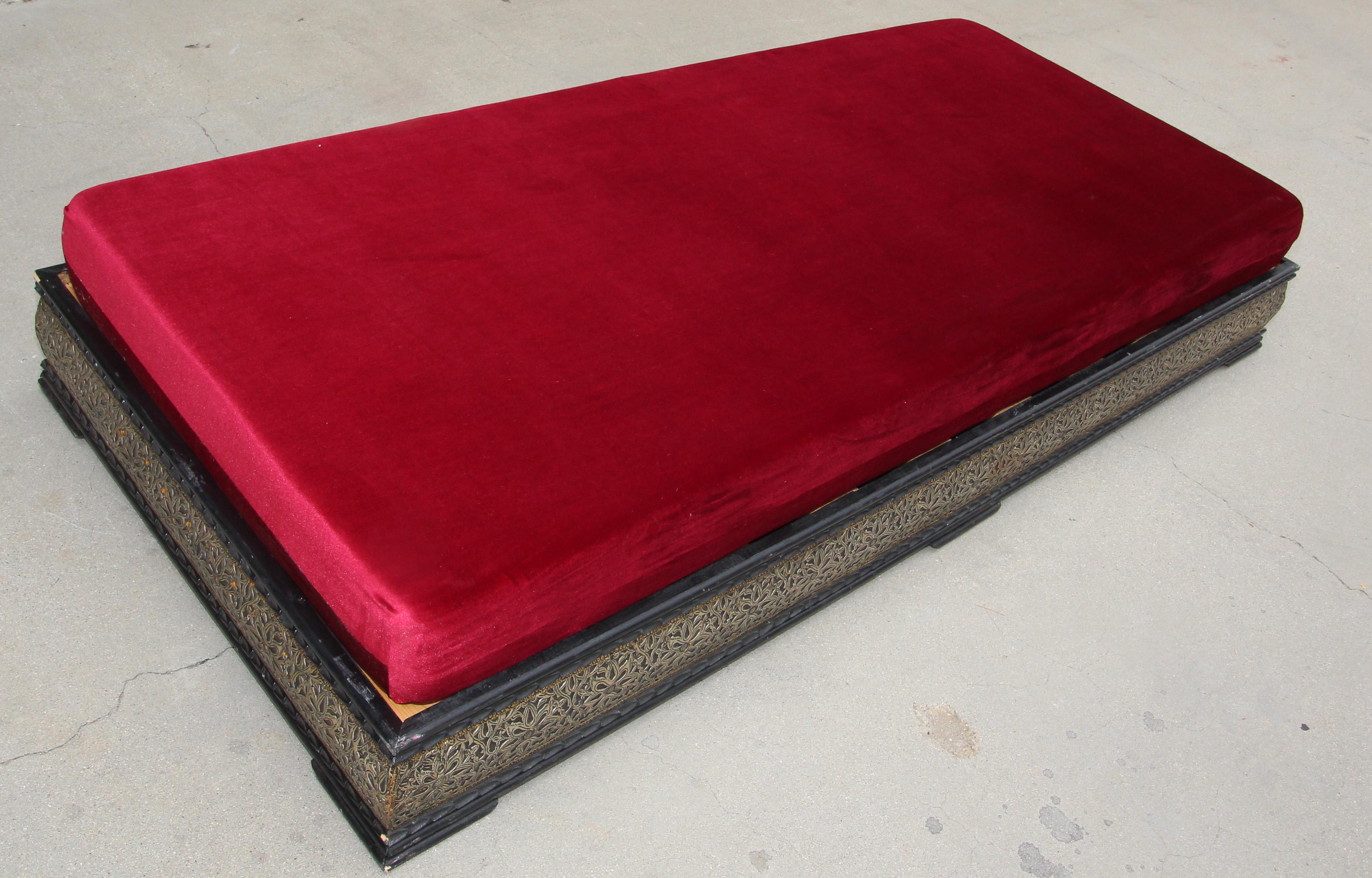 Vintage Moroccan low bench, day bed.
Traditional Moroccan sofa, low bench handcrafted in a wooden base adorned with silvered metal with traditional geometric design, top cushion foam covered with a red velvet fabric.
Moroccan upholstered settee with