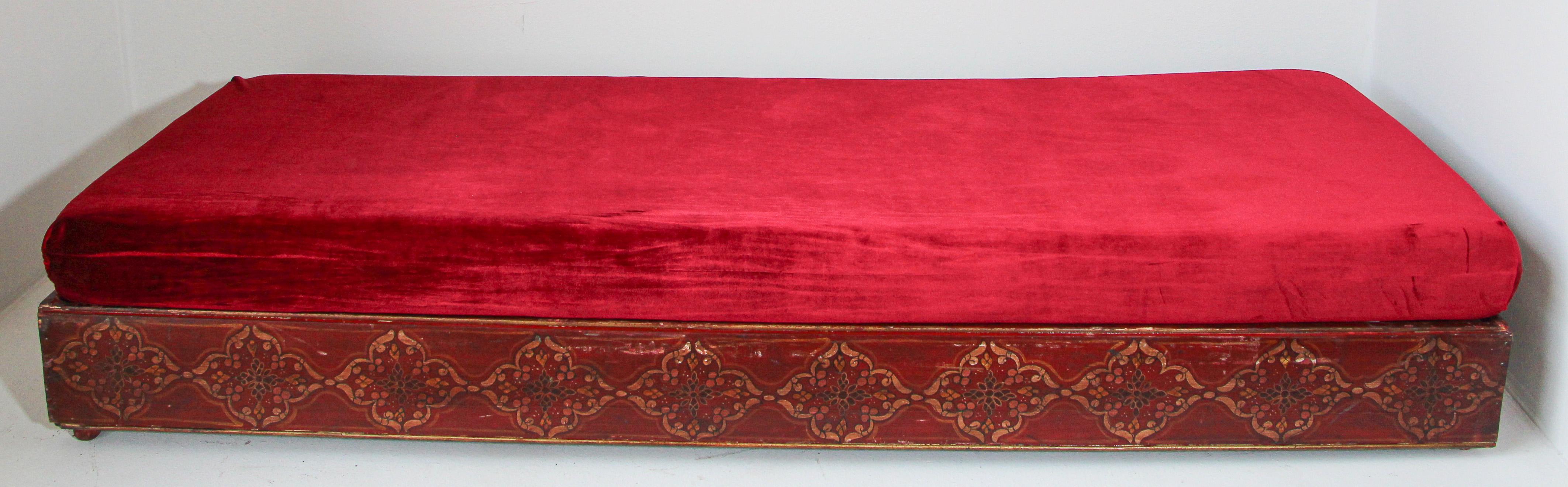 Vintage Moroccan low wooden bench, day bed.
Traditional Moroccan sofa, low bench handcrafted in a wooden base hand-painted with traditional geometric design, top cushion foam covered with a red velvet fabric.
Moroccan upholstered settee with