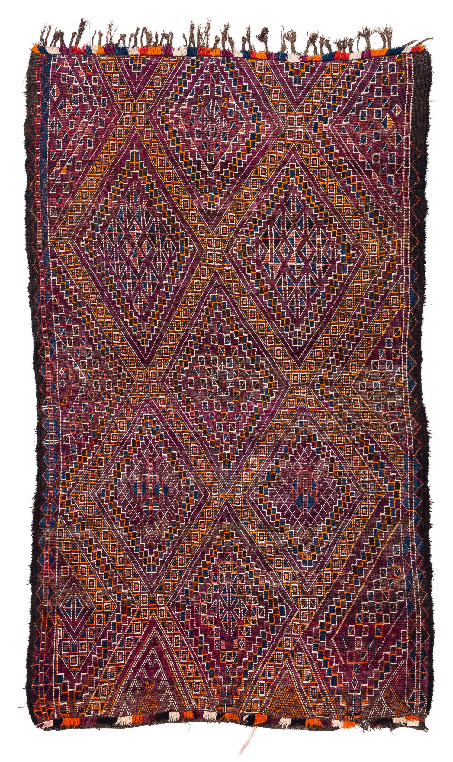 This antique vintage Moroccan rug came from the Beni Mguild tribe from the central middle Atlas mountains. This rug features beautiful dye, exhibiting rich color glowing colors. It was an authentic Berber piece, originally commissioned in the mid