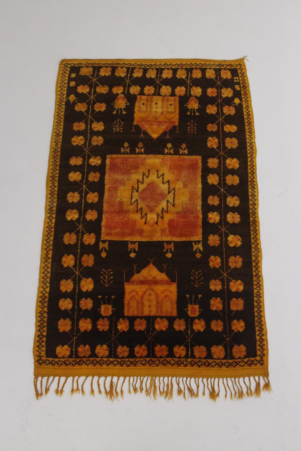 I selected this beautiful rug from piles of carpets because I have always loved a good vintage Taznakht rug with bright, saffron color. The background color of this one is a dark brown with saffron and faded red designs all over it. You can spot