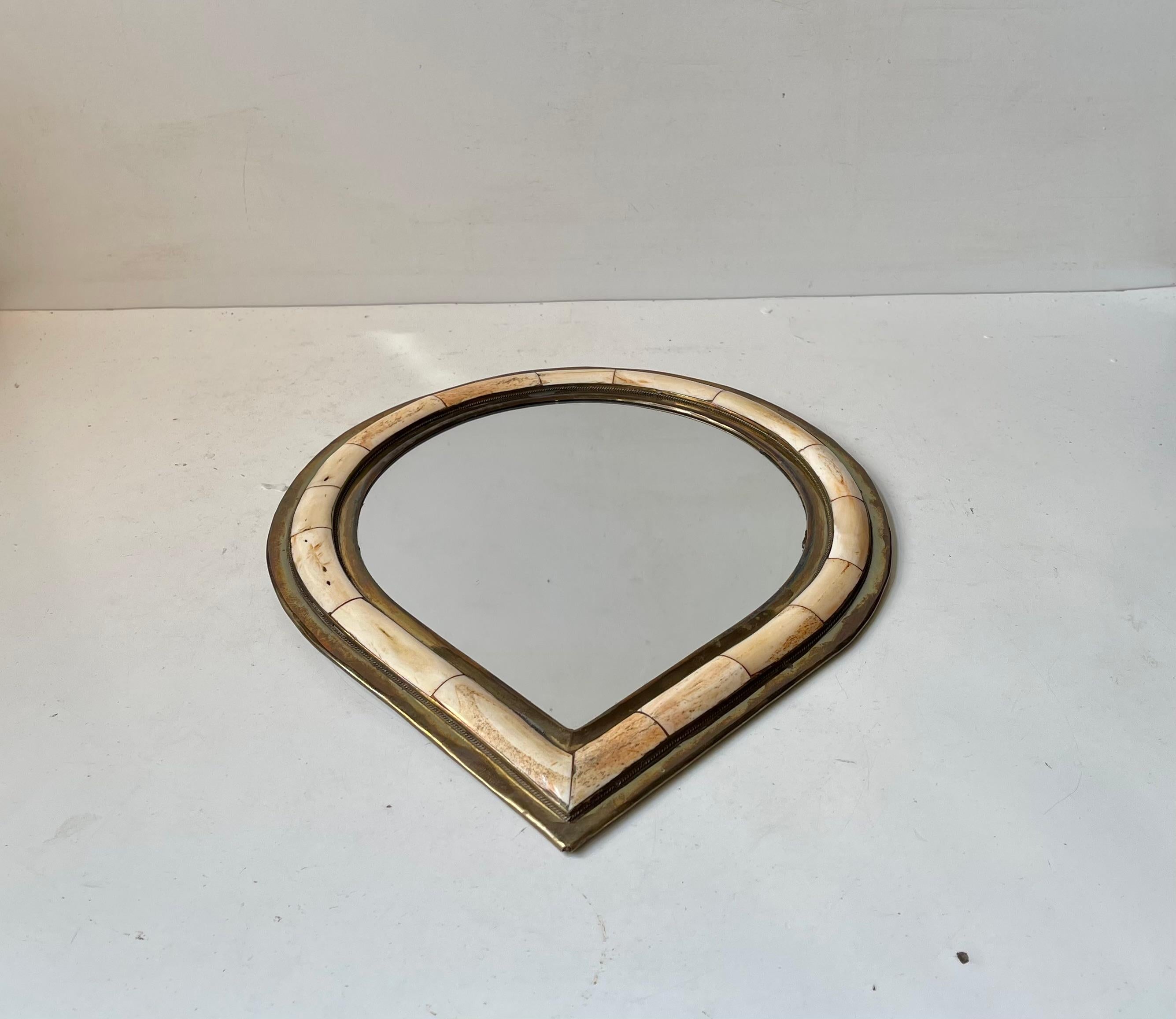 Artisan hand-made small wall- or vanity mirror executed in brass and set with rectangles of cut, rounded and polished camel bone. Made in Morocco where it was brought home by a Danish tourist during the 1970s or 80s. Suitable for spicy moroccan