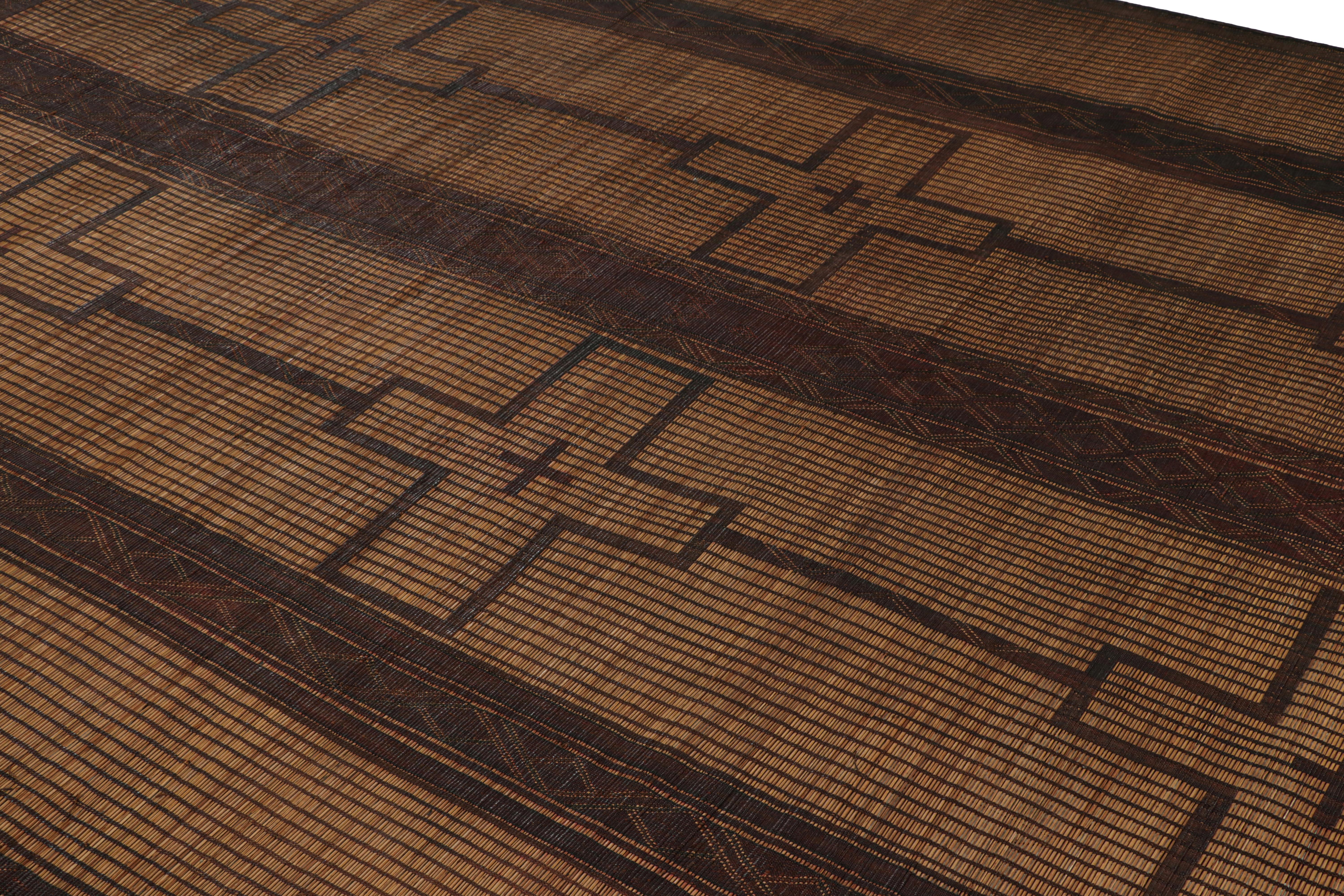 Dieser marokkanische Vintage-Bodenbelag ist eine 8x11 große Tuareg-Matte des gleichnamigen Nomadenstamms. Handgeflochten mit Schilf und Leder um 1950-1960, seine natürlichen Materialien erfreuen sich an warmen Beige-, Braun- und Schwarztönen in