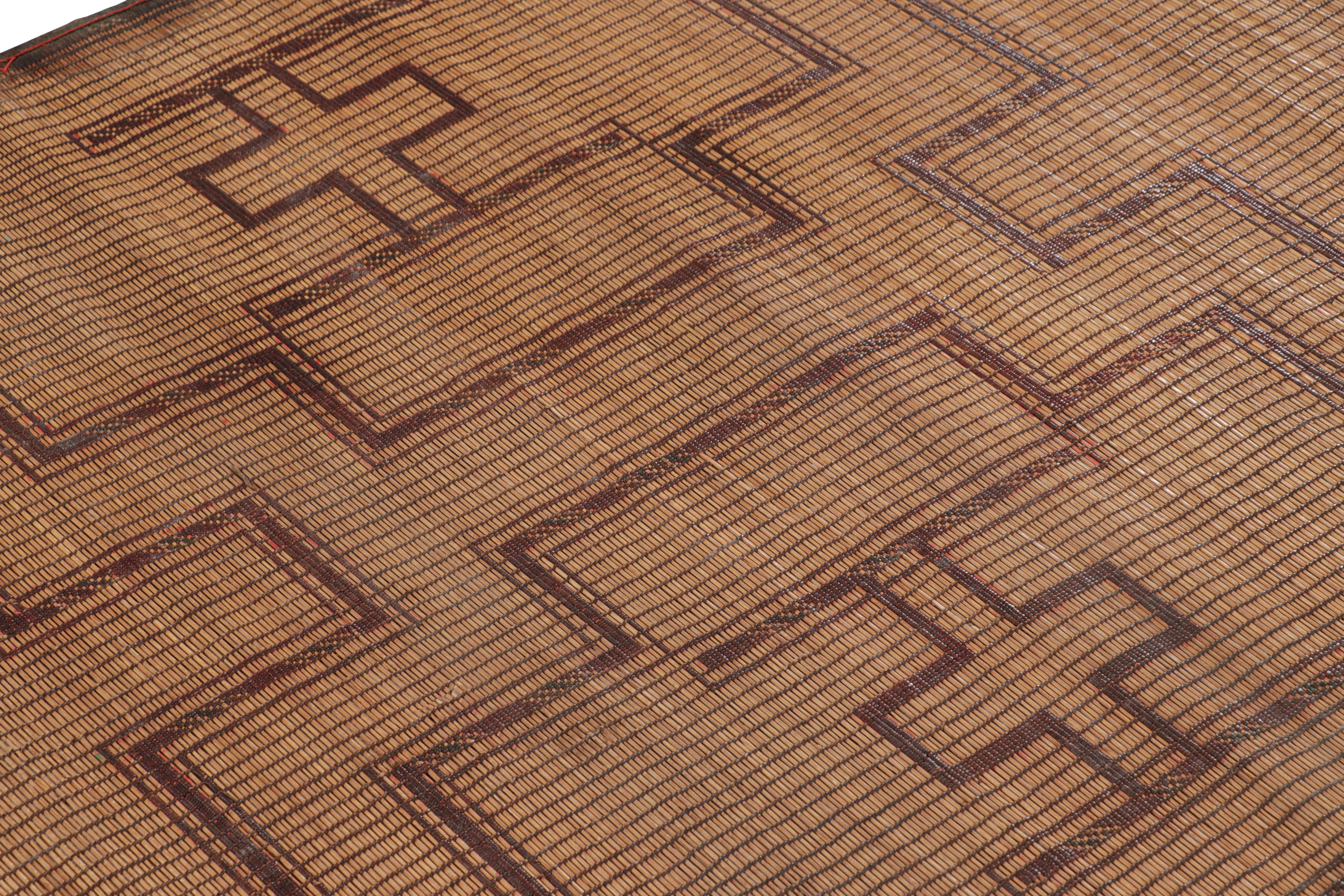 This vintage Moroccan floor covering is a 4x5 Tuareg mat from the nomadic tribe of the same name. Handwoven with reeds and leather circa 1950-1960, its natural materials enjoy warm brown, red and black tones in its geometric patterns.

On the