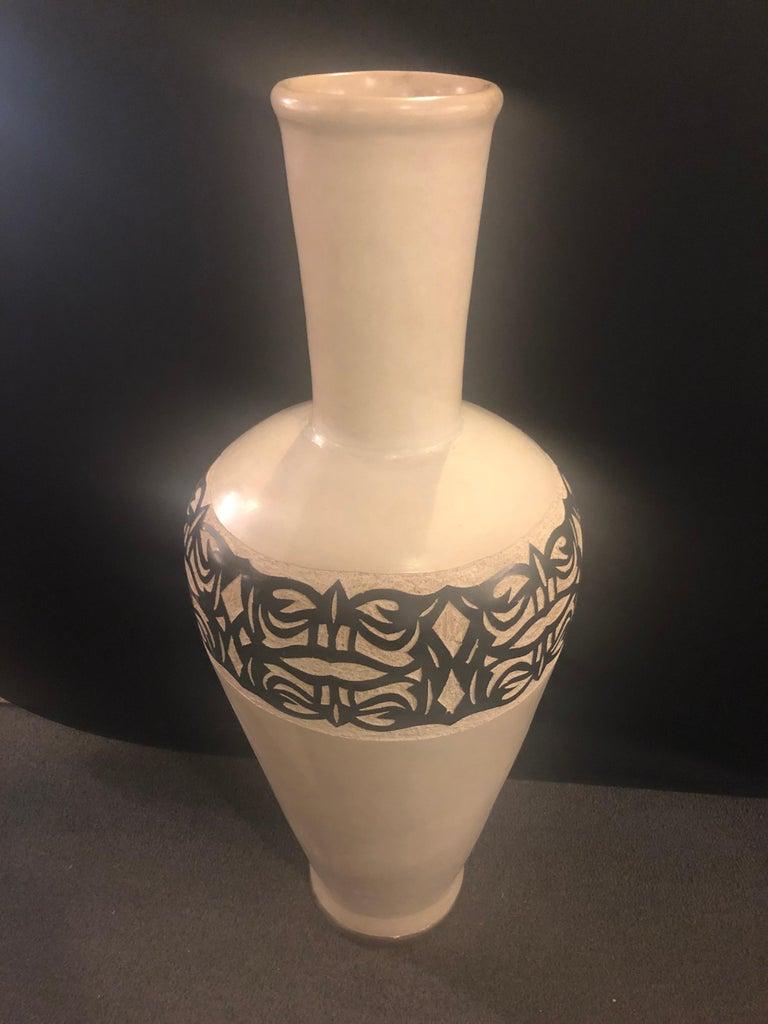 A beautiful vintage handmade pottery floor vase. The vase features an elegant earthy off-white natural color with decorative motifs hand painted by master artisans in the Atlas Mountains in Morocco.
Opening dimensions 7.25