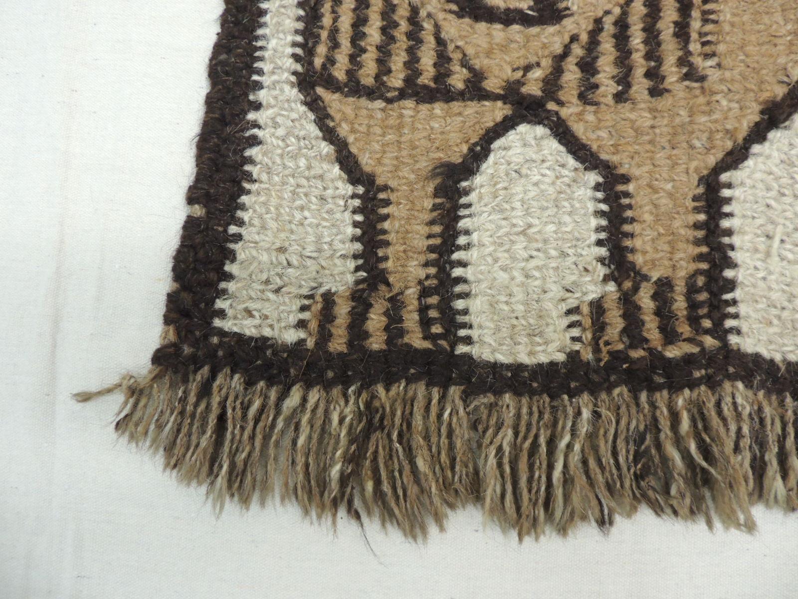 Vintage African woven decorative rug with handwoven fringes
depicting a lion. In shades of brown, tan and natural
Size: 26