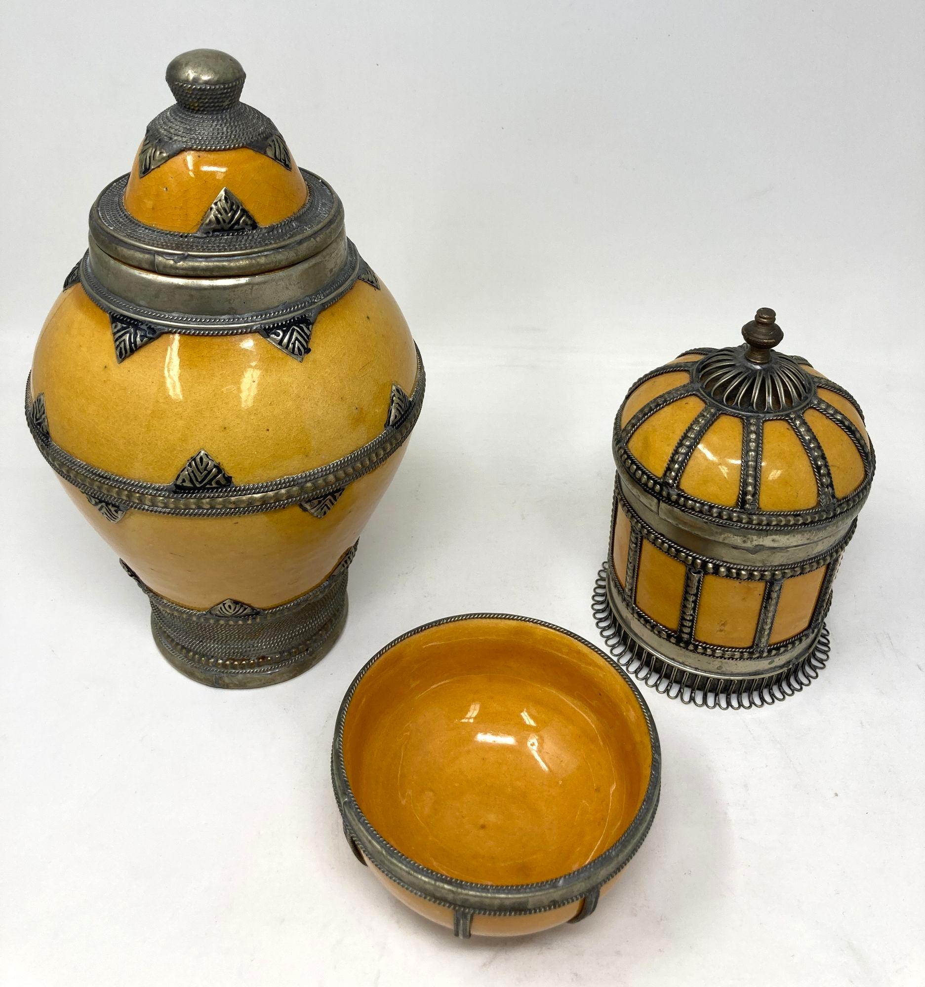 Bellissimo set di 3 vasi e ciotole in ceramica gialla marocchina vintage con sovrapposizione di filigrana d'argento.
Il set di ceramiche marocchine comprende una grande urna con coperchio, una piccola scatola con coperchio e una piccola ciotola,
