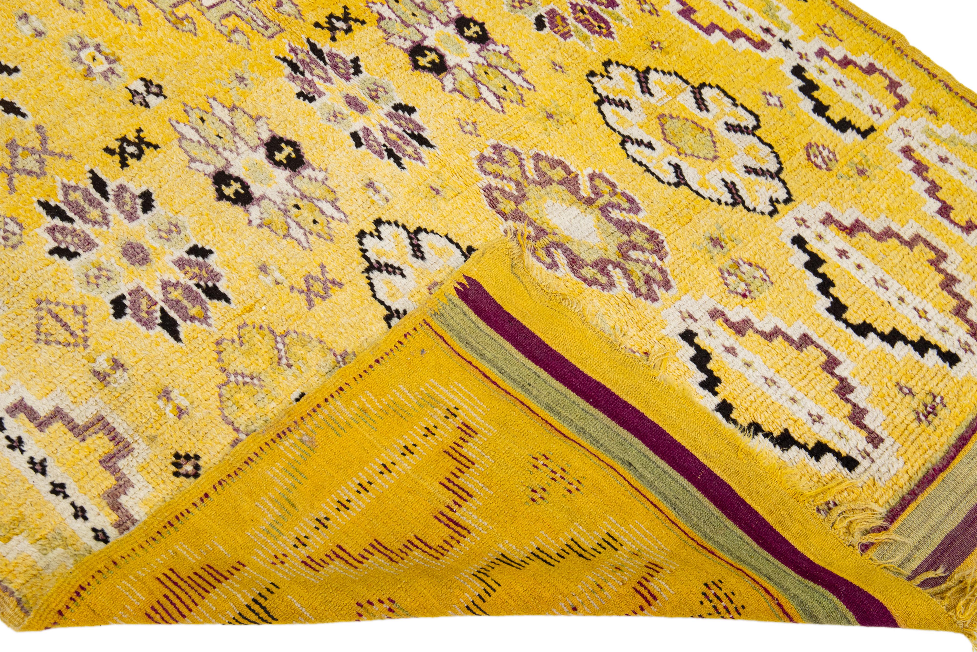 Schöner handgefertigter Wollteppich im marokkanischen Vintage-Stil mit einem gelben Feld und mehrfarbigen Akzenten, die ein wunderschönes geometrisches Muster aufweisen.

Dieser Teppich misst: 5' x 12'.

Unsere Teppiche werden vor dem Versand