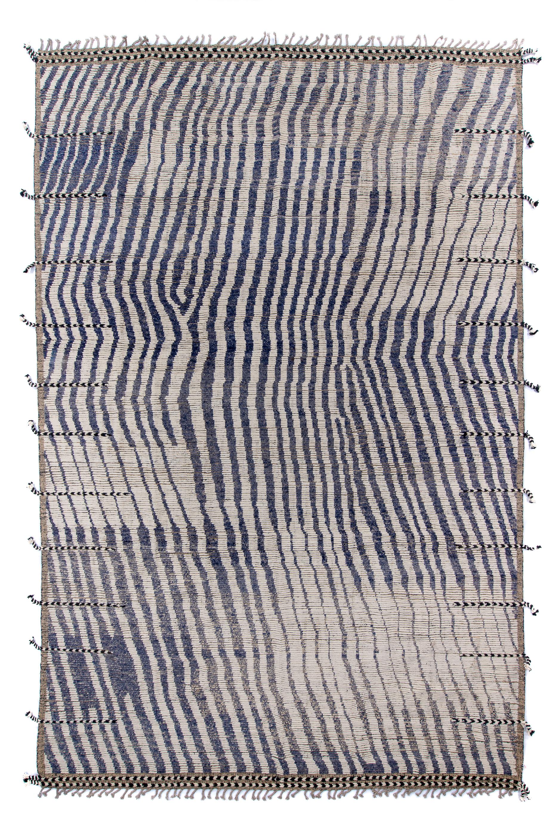 With side and end tassels, this is a two tone, cream and near black, striped rug with a pronounced bend toward one side. The rug looks a bit tipsy with its moire pattern. The stripes thicken and thin, and there are a couple of joins toward one