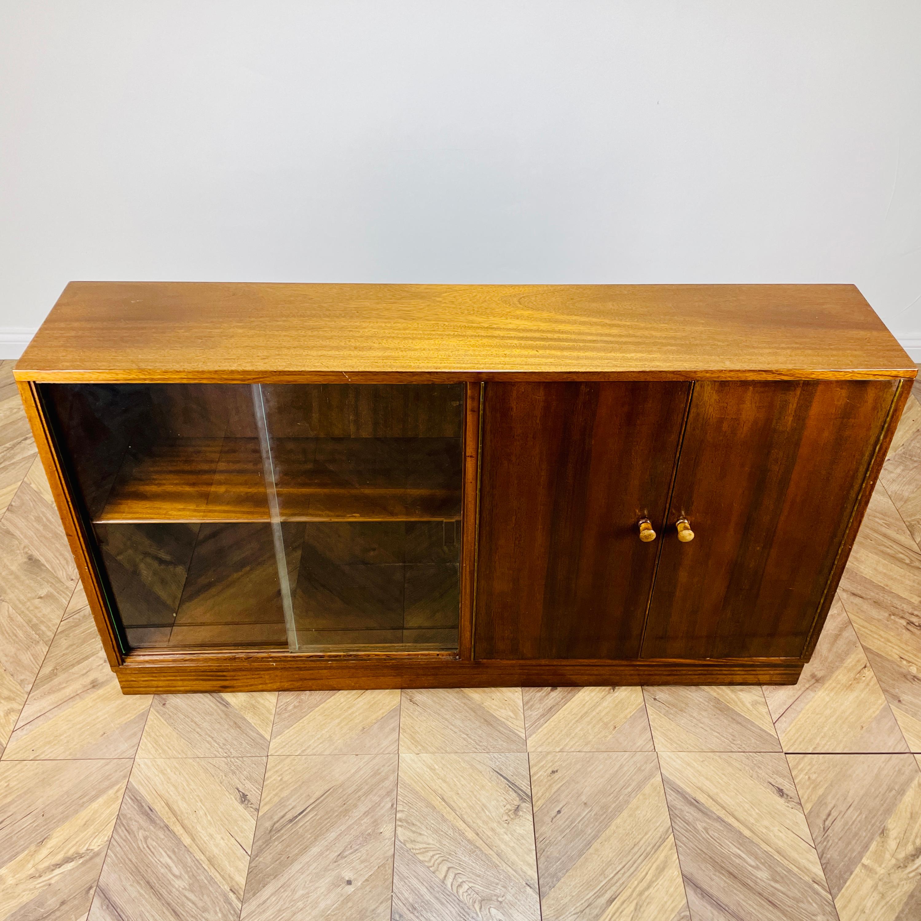 Simple, yet beautifully designed display cabinet by Neil Morris for Morris of Glasgow, circa 1950s / 1960s.

The cabinet consists of two storage sections, to the left hand side of the bookcase there are two glass sliding doors with two shelves