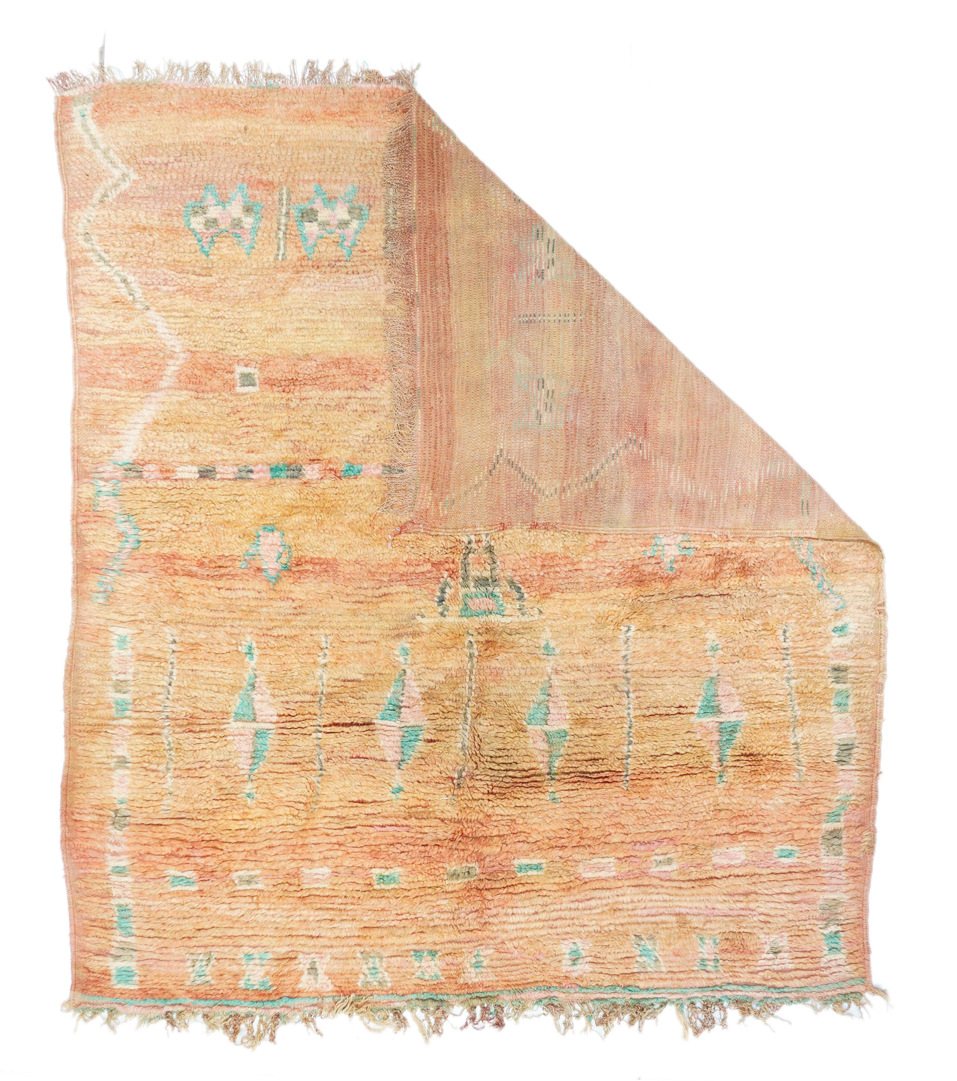 Tapis marocain vintage 5'11'' x 6'9''. La pile très épaisse, fortement abrasée, de couleur saumon brûlé à fauve doré, présente un motif occasionnel de losanges à quartes élevés, de petits carrés, de sabliers triangulaires, de zigzags audacieux et de