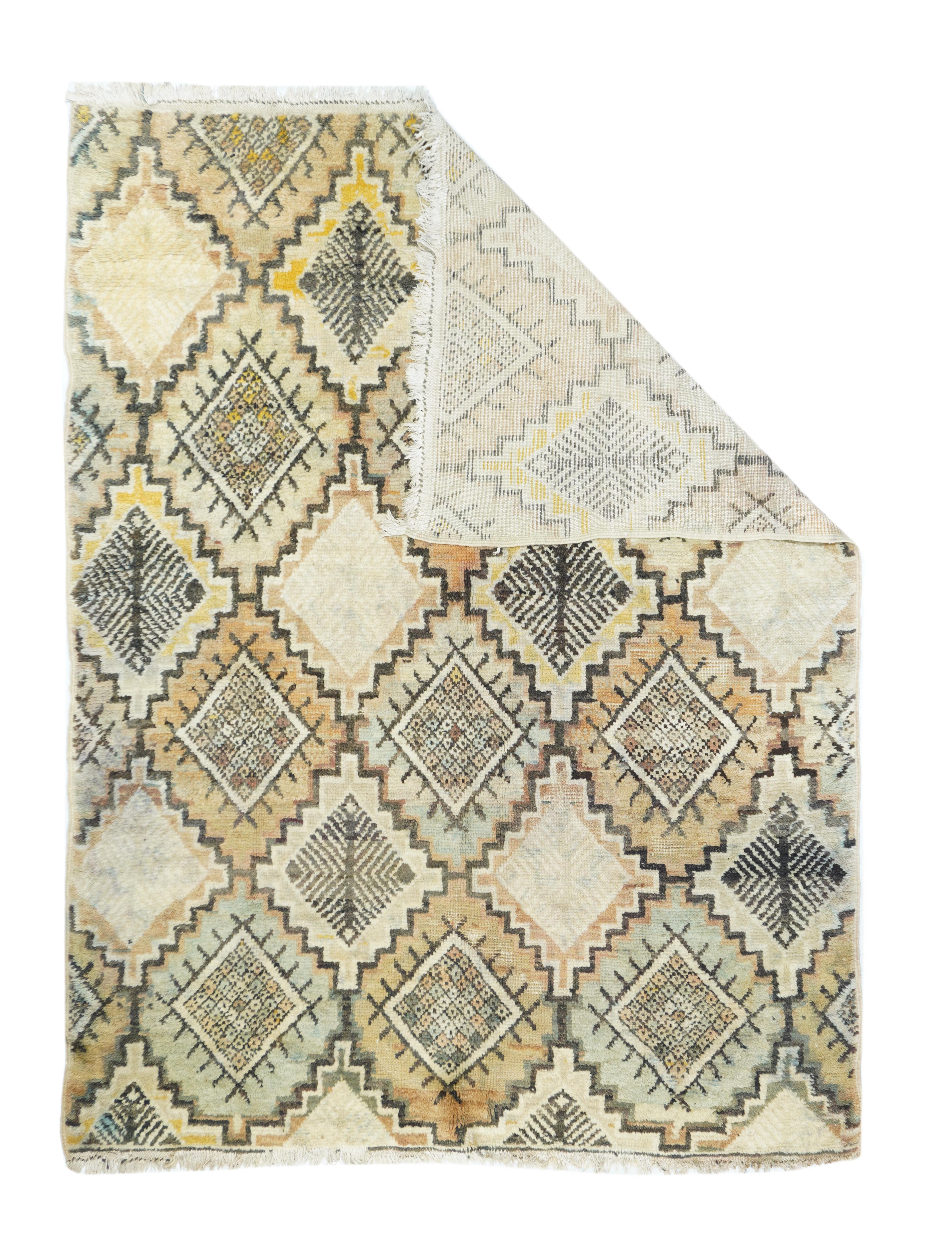 Vintage Morrocan Rug 5'4'' x 7'2''. This totally borderless Berber, coarse weave, high pile scatter, shows a stepped lozenge lattice with the reserves displaying fringed lozenges of quadruple herringbone devices. Straw, sand, pale green, brown and