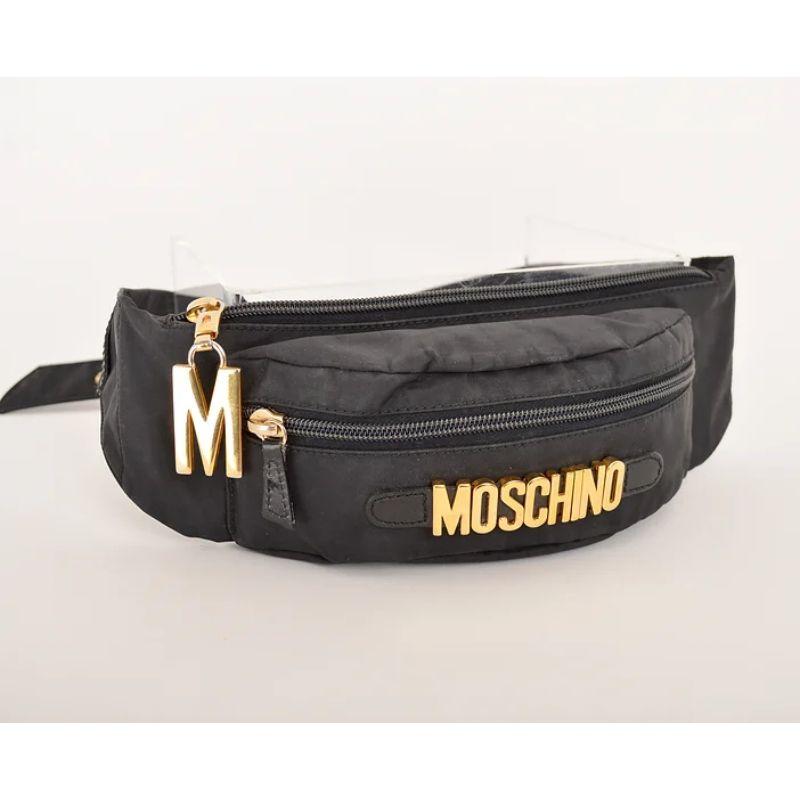 Vintage 1990's Moschino black nylon waist belt / ''bum bag'', with iconic 'MOSCHINO' lettering and  gold tone metal hardware.

MADE IN ITALY !

Features;
'MOSCHINO' spellout letters
x2 Zip fasten compartments
Gold tone metal hardware
Adjustable