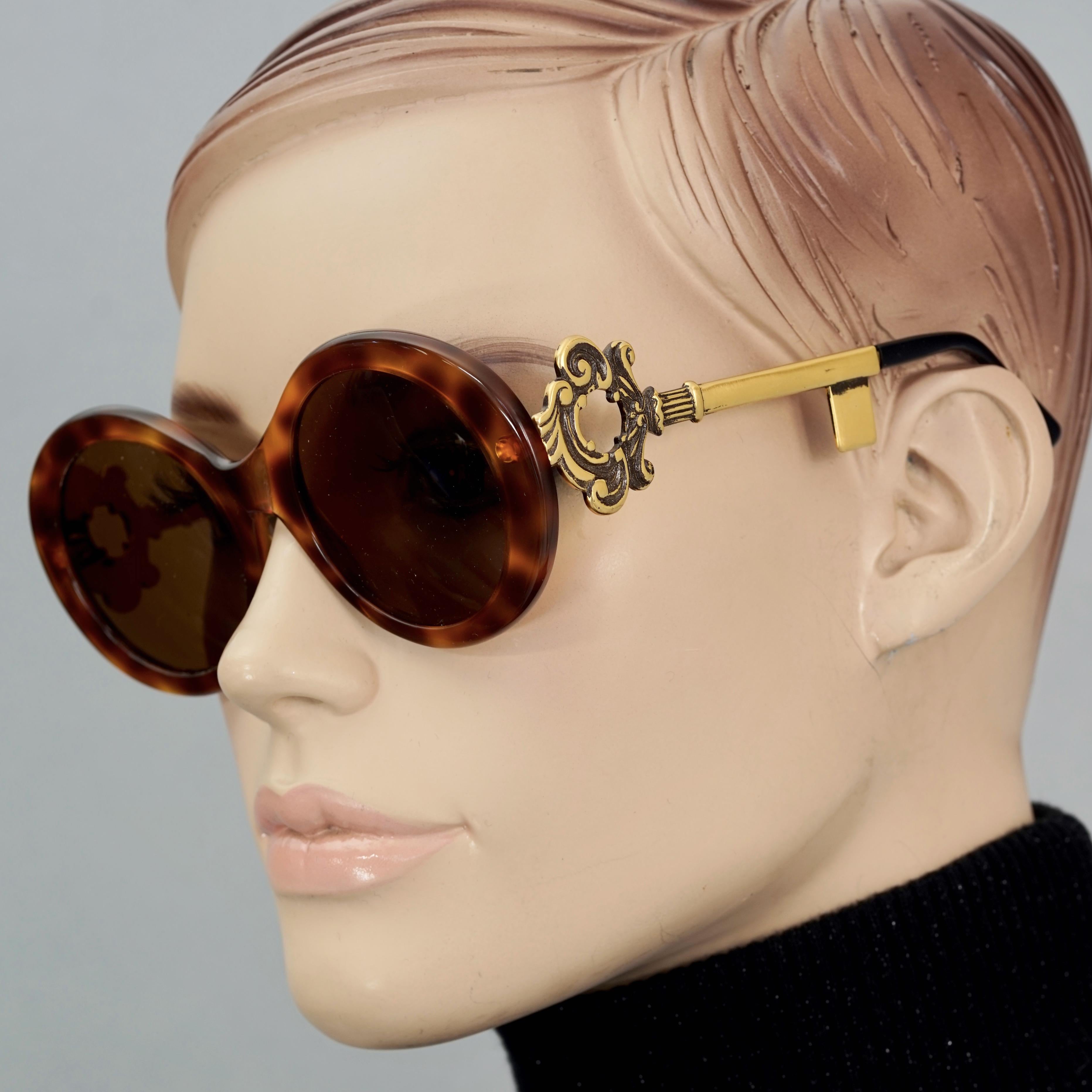 Vintage MOSCHINO Baroque Key Round Tortoiseshell Novelty Sunglasses

Measurements:
Height: 2.16 inches (5.5 cm)
Horizontal Width: 5.39 inches (13.7 cm)
Arms: 5.11 inches (13 cm)

Features:
- 100% Authentic MOSCHINO. 
- Round tortoiseshell sunglasses