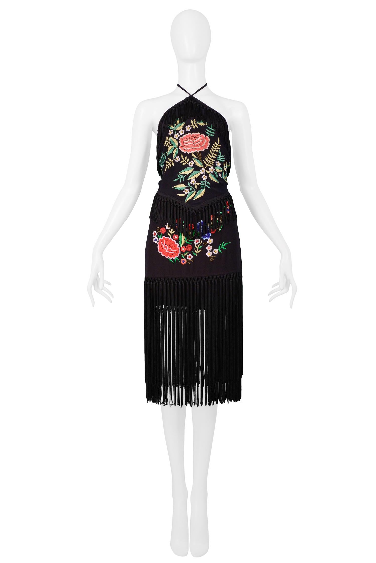Vintage Moschino black embroidered floral halter top and matching skirt ensemble with fringe detail. Top has ties at neck and back, and skirt is wrap style with button closure at waist.

Excellent Vintage Condition.

Top Size: 44
Skirt Size: 44

Top