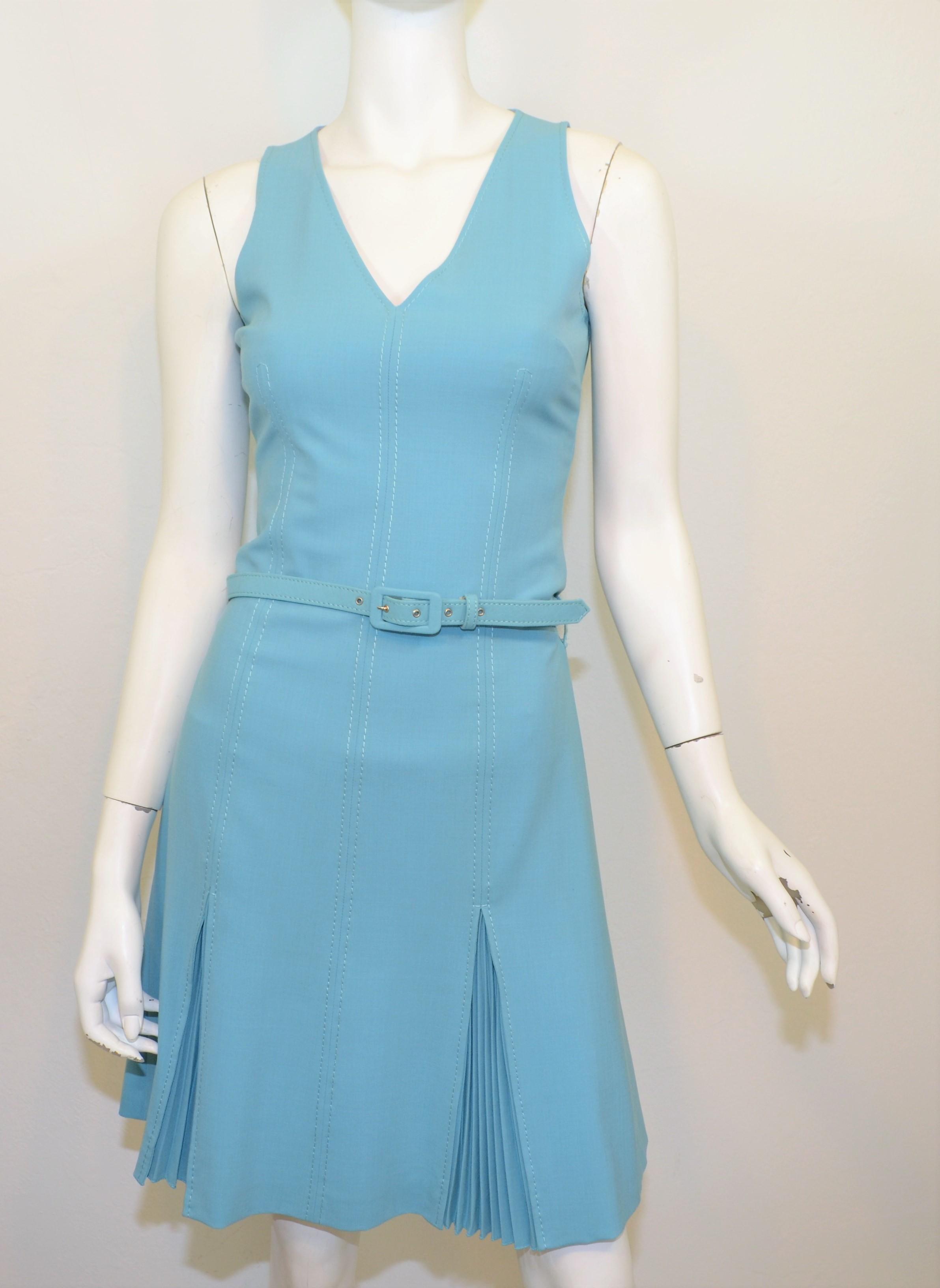Vintage Moschino dress is featured in a light blue color with white stitching and has a back zipper fastening along with a belt. Dress has a pleated skirt and is fully lined. Made in Italy, US size 6, composed with mixed fibers.