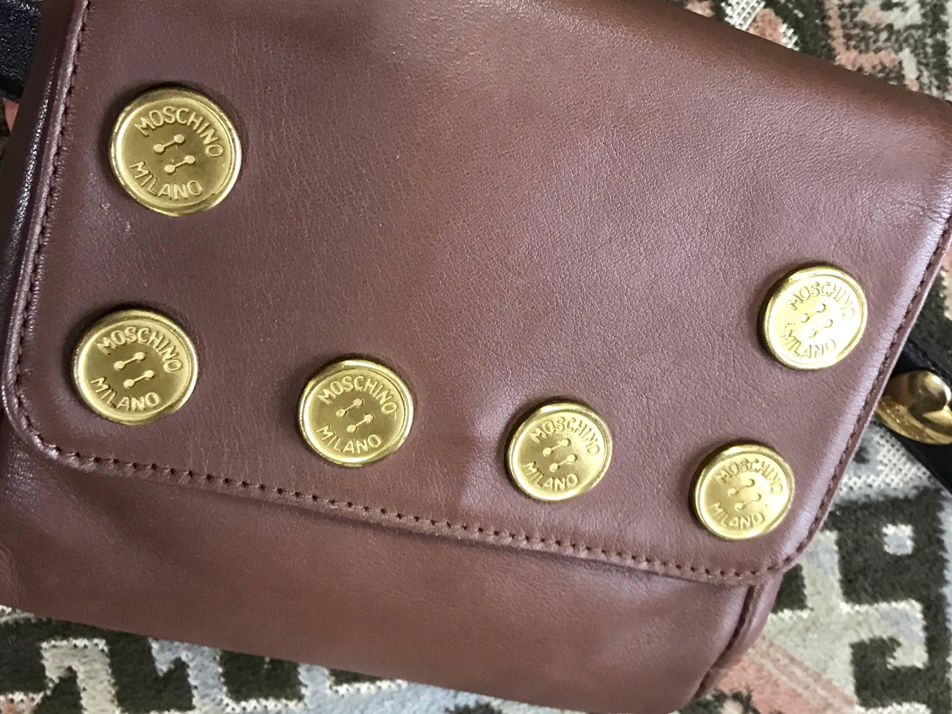 1990s. Vintage MOSCHINO brown leather waist purse, fanny pack, clutch bag with button motifs. Comes with chocolate brown belt with heart motifs.

This is a vintage MOSCHINO, cute shape brown leather waist purse/fanny pack with logo embossed button