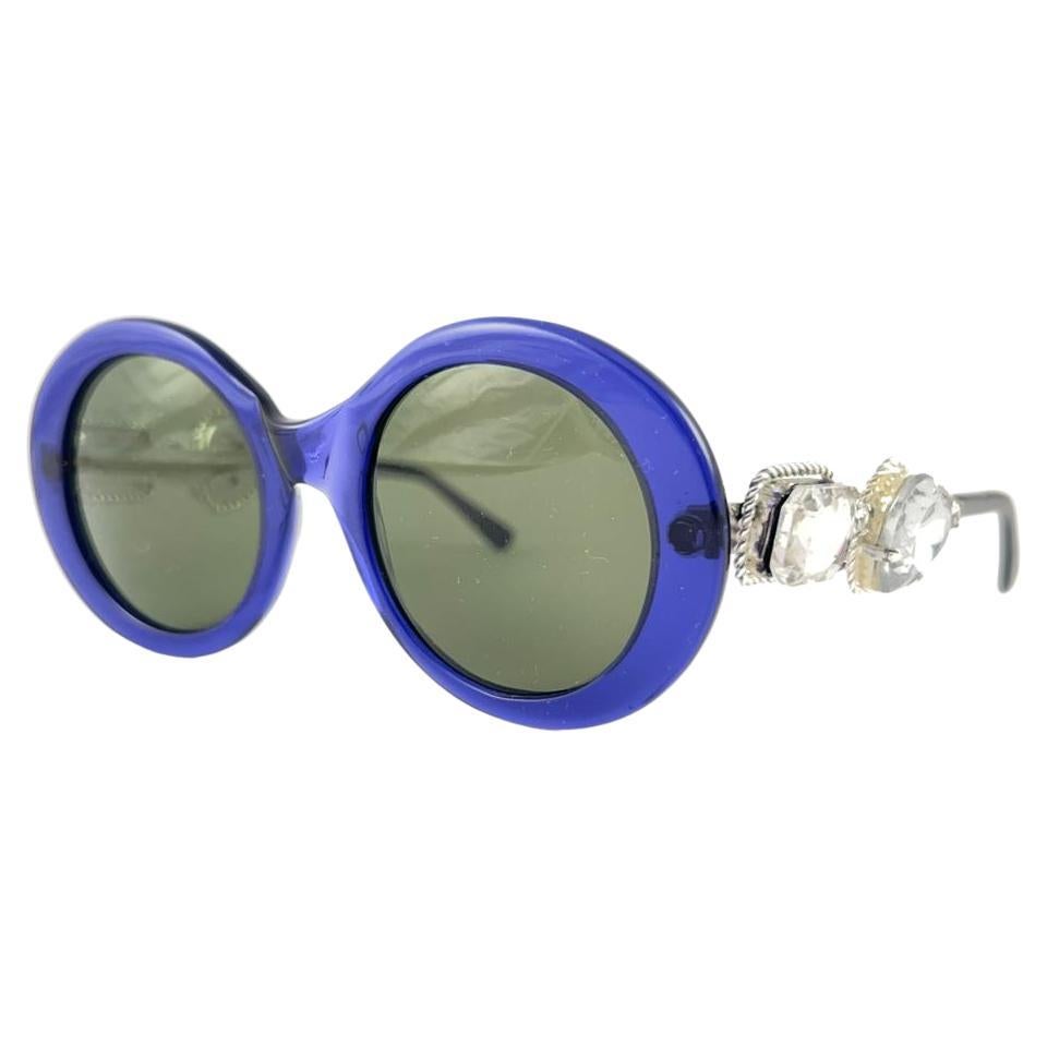 Rare Vintage Moschino oval with jewell details frame. Grey lenses.
The very same model worn by Lady Gaga.

Made in Italy.

FRONT : 13.5 CMS

LENS HEIGHT : 4.6 CMS

LENS WIDTH : 4.8 CMS

This item show minor wear on the frame due to storage.