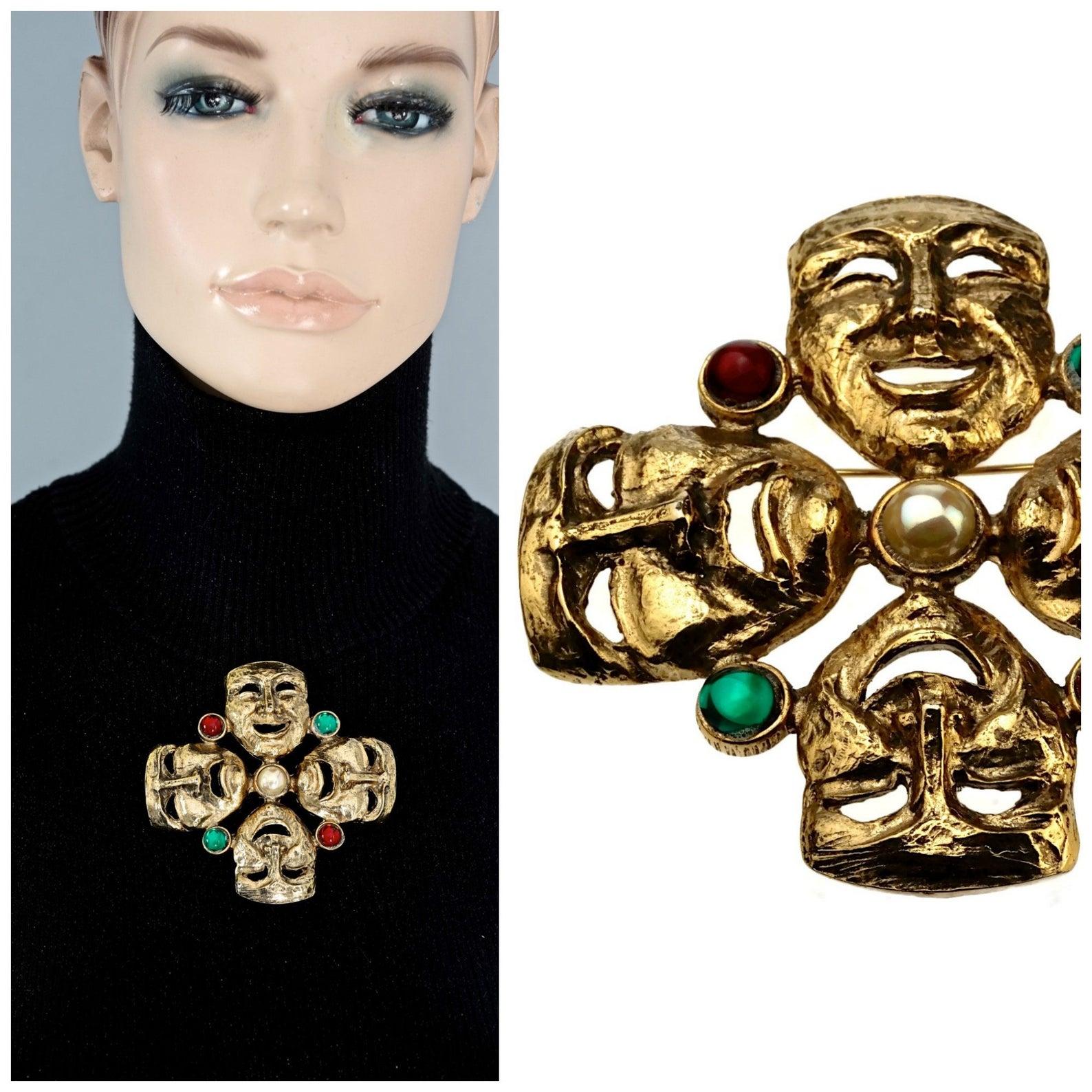 Vintage MOSCHINO Comedy Tragedy Mask Jewelled Novelty Brooch

Measurements:
Height: 3.42 inches (8.7 cm)
Width: 3.42 inches (8.7 cm)

Features:
- 100% Authentic MOSCHINO.
- Comedy and tragedy masks brooch with pearl, red and green cabochons.
- Gold