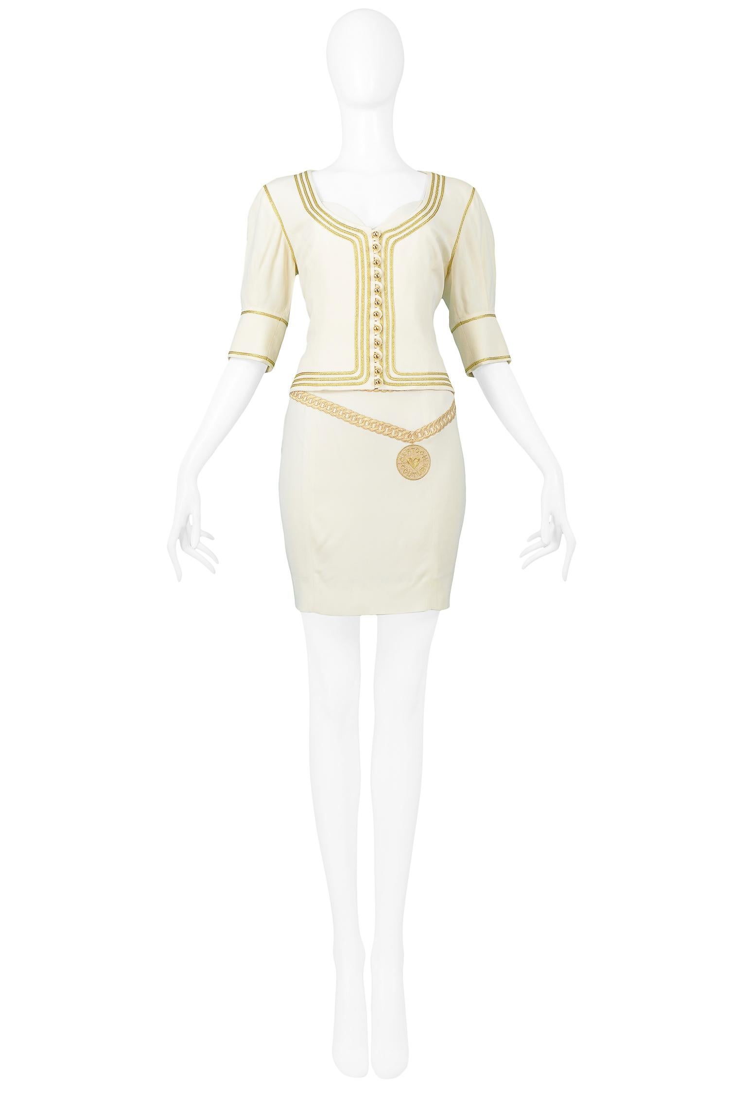 Resurrection Vintage is excited to offer a vintage off-white Moschino Couture by Franco Moschino rayon blend, gold-embroidered dress, and jacket ensemble. The jacket features gold buttons at the center front opening, elbow-length sleeves, and gold