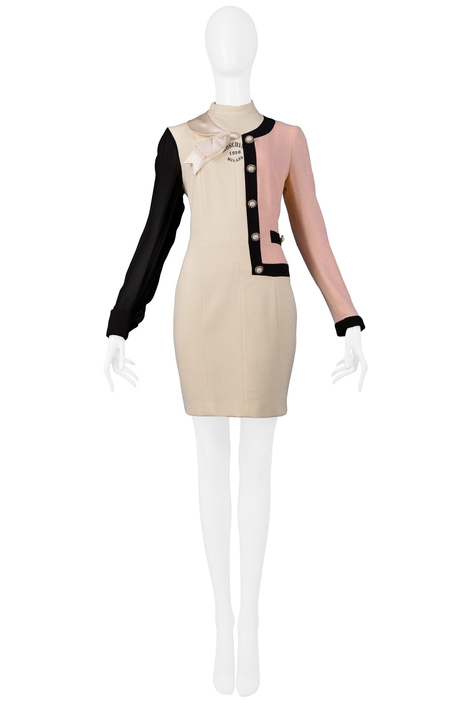Resurrection Vintage is excited to offer a vintage 1990s Moschino Trompe l'oeil dress. The dress features half of a pink Chanel inspired suit jacket with black trim and pearl buttons, a black sleeve, a high collar, satin bow, an invisible center