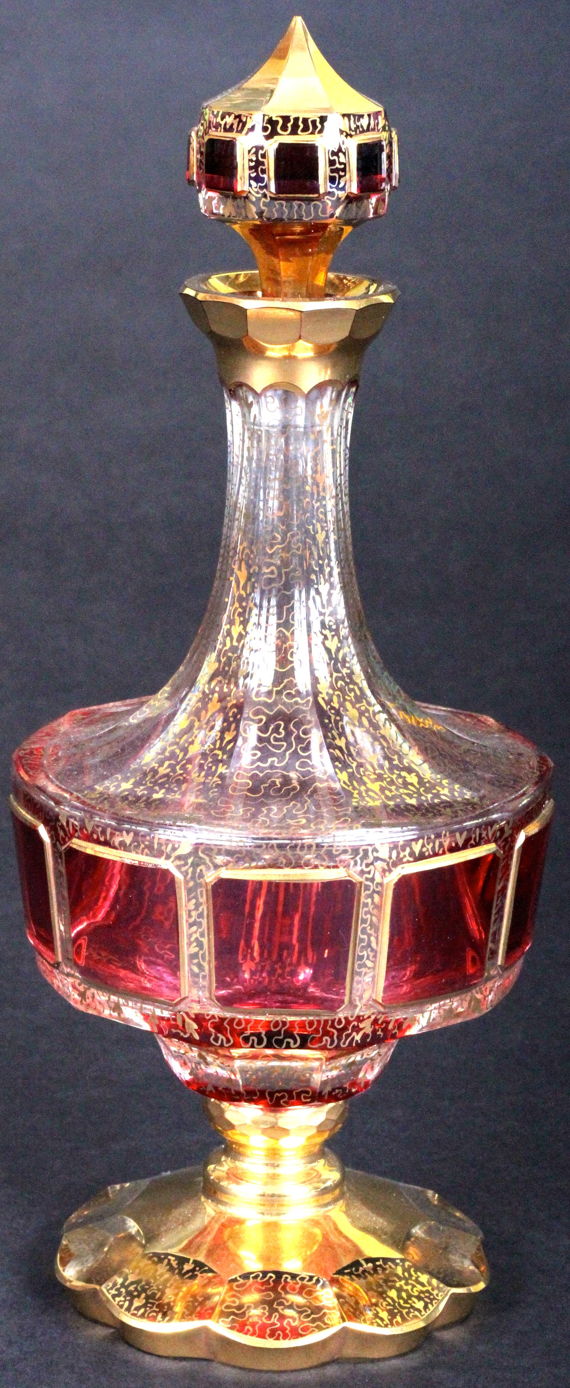 Here is a lovely Bohemian cranberry cordial set consisting of a decanter and 6 glasses, made by Moser Glass, Czech Republic.

The decanter and glasses feature raised panels of rich cranberry cabochon 