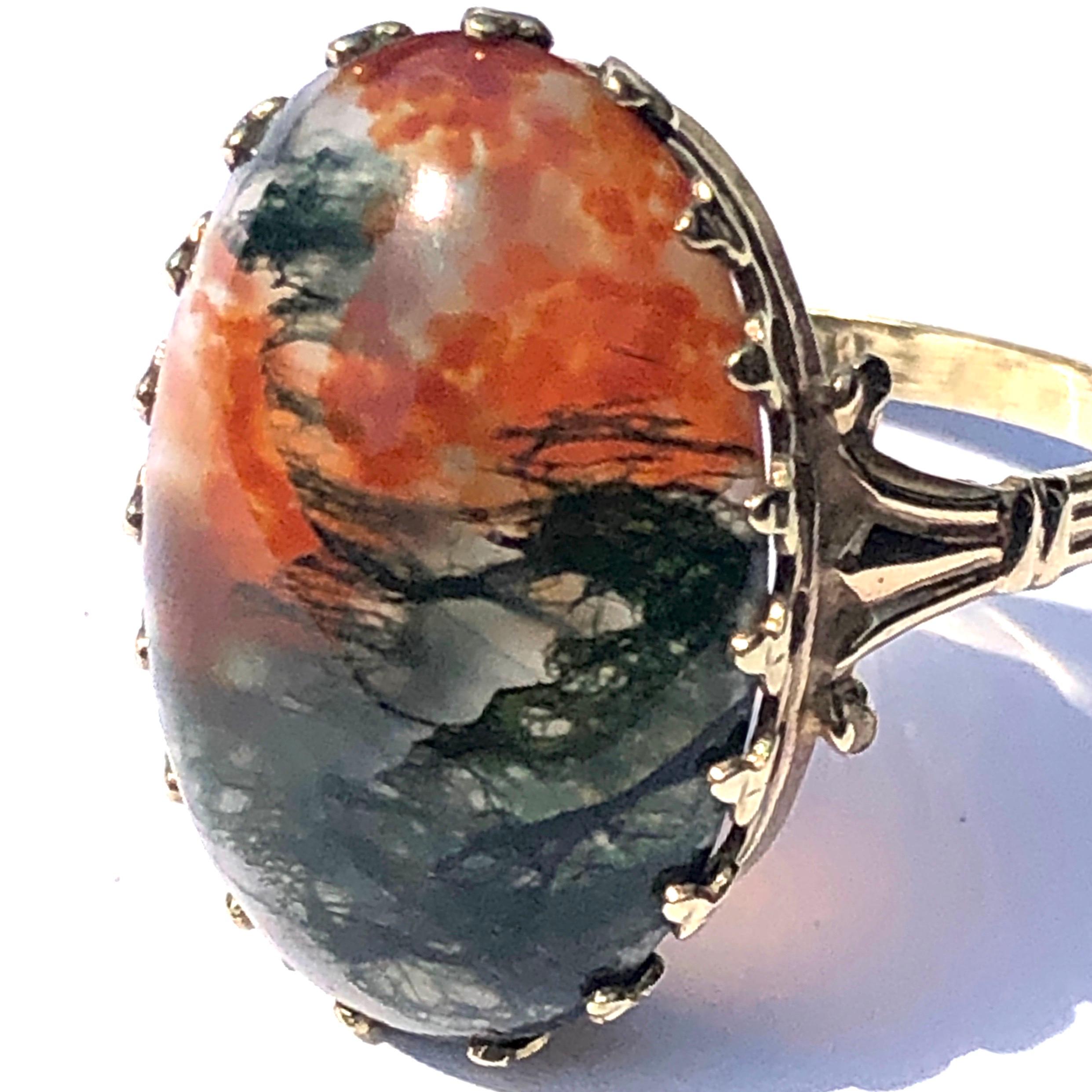 Set into the 9ct gold ring is a gorgeous moss agate with so many wonderful colours marbled through it. The stone has a rich red and orange colour and also a dark green with all tones in-between running through it. The setting is almost crown like in