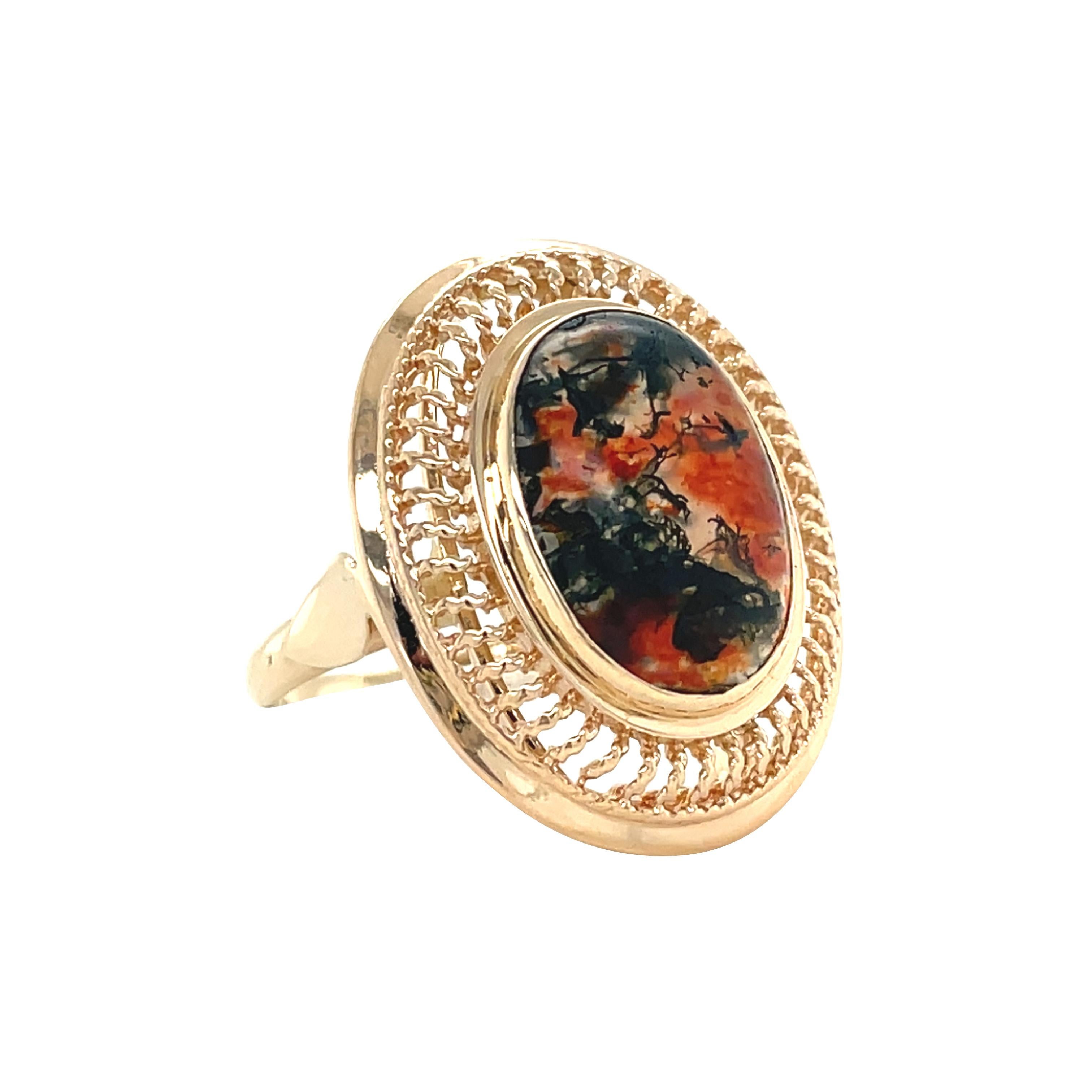 Dieser farbenprächtige Ring im Vintage-Stil zeigt einen atemberaubenden Moosachat in einer detaillierten Goldfassung. Die geflochtenen Umrandungsdetails lenken den Blick auf die Schönheit und Komplexität des Mittelsteins. Der Moosachat ist nicht nur