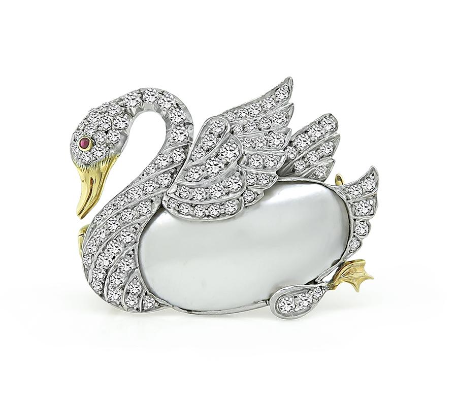 This is a magnificent platinum and gold swan pin from the 1920s. The pin is set with sparkling old European cut diamonds that weigh approximately 1.50ct. The color of these diamonds is H with VS clarity. The diamonds are accentuated by mother of