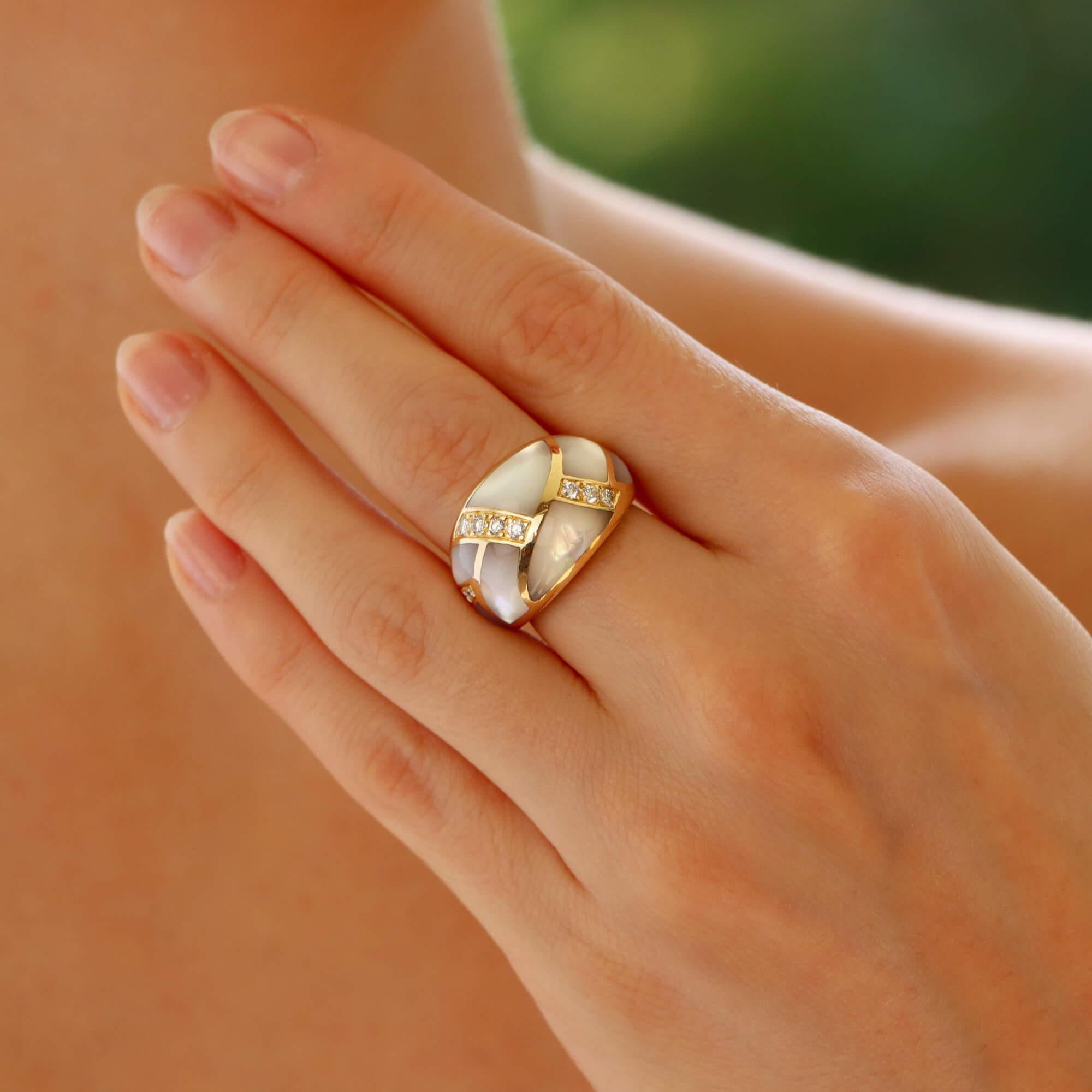 A beautiful vintage mother of pearl and diamond bombé ring set in 14k yellow gold.

The ring is designed in a raised bombé design and is set with a rub over set pieces of mother of pearl and claw set diamonds.

Due to the design, this piece stands