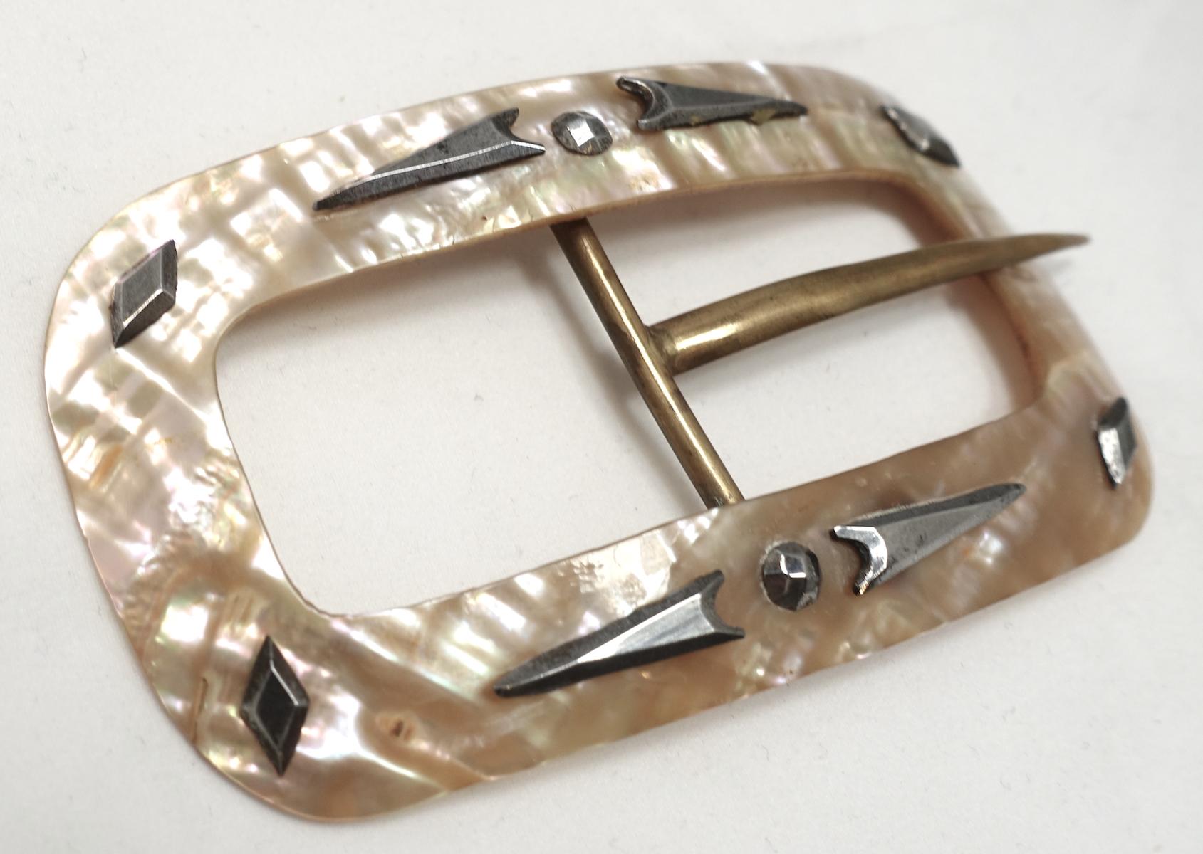This vintage belt buckle is made of Mother of Pearl and has silver tone accents and gold tone belt piece.  In excellent condition, this buckles measures 3-3/4” x 2”.