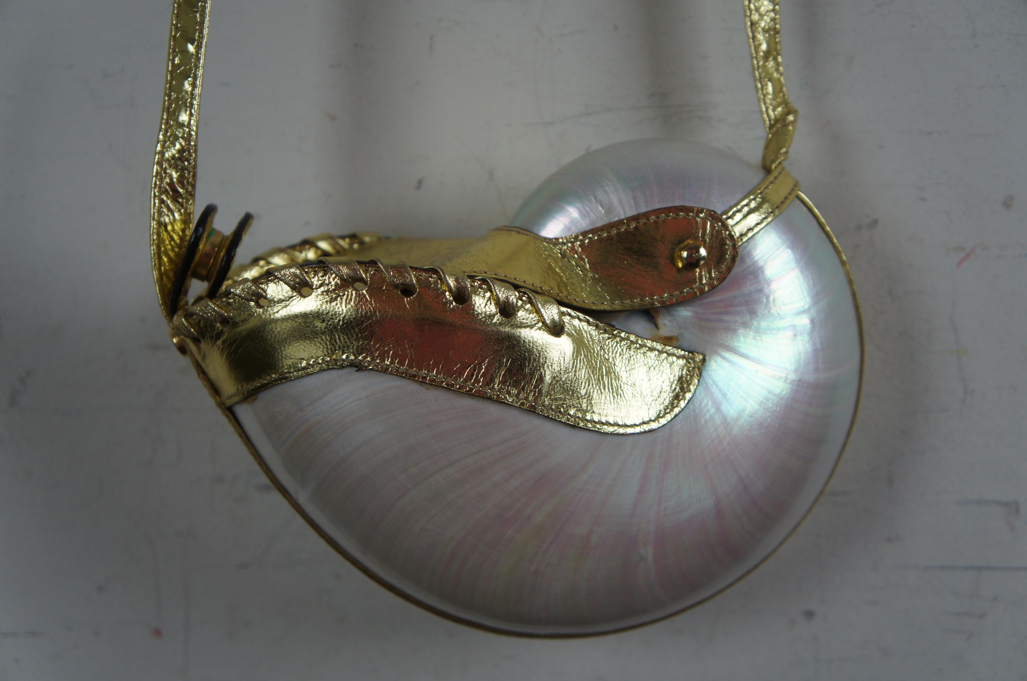 Mother of pearl nautilus purse with gold leather strap and closure, circa 1970s.

Measures: 7