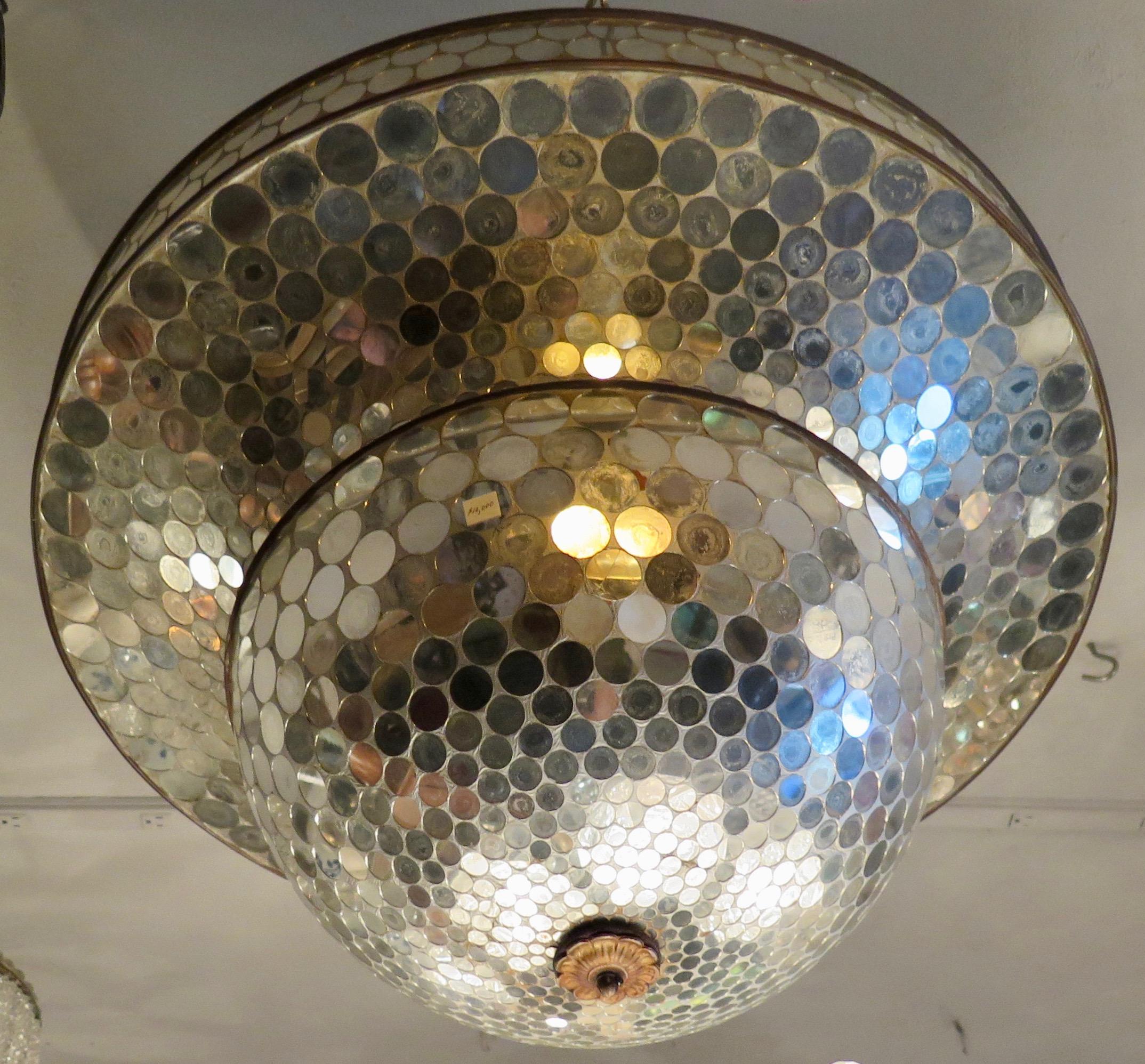This early 20th century collectable ceiling fixture has a tiered circular dome form. Each tier of the dome is decorated with small, round, mirrored discs that cover the entire surface of the fixture. When illuminated by external light sources, a