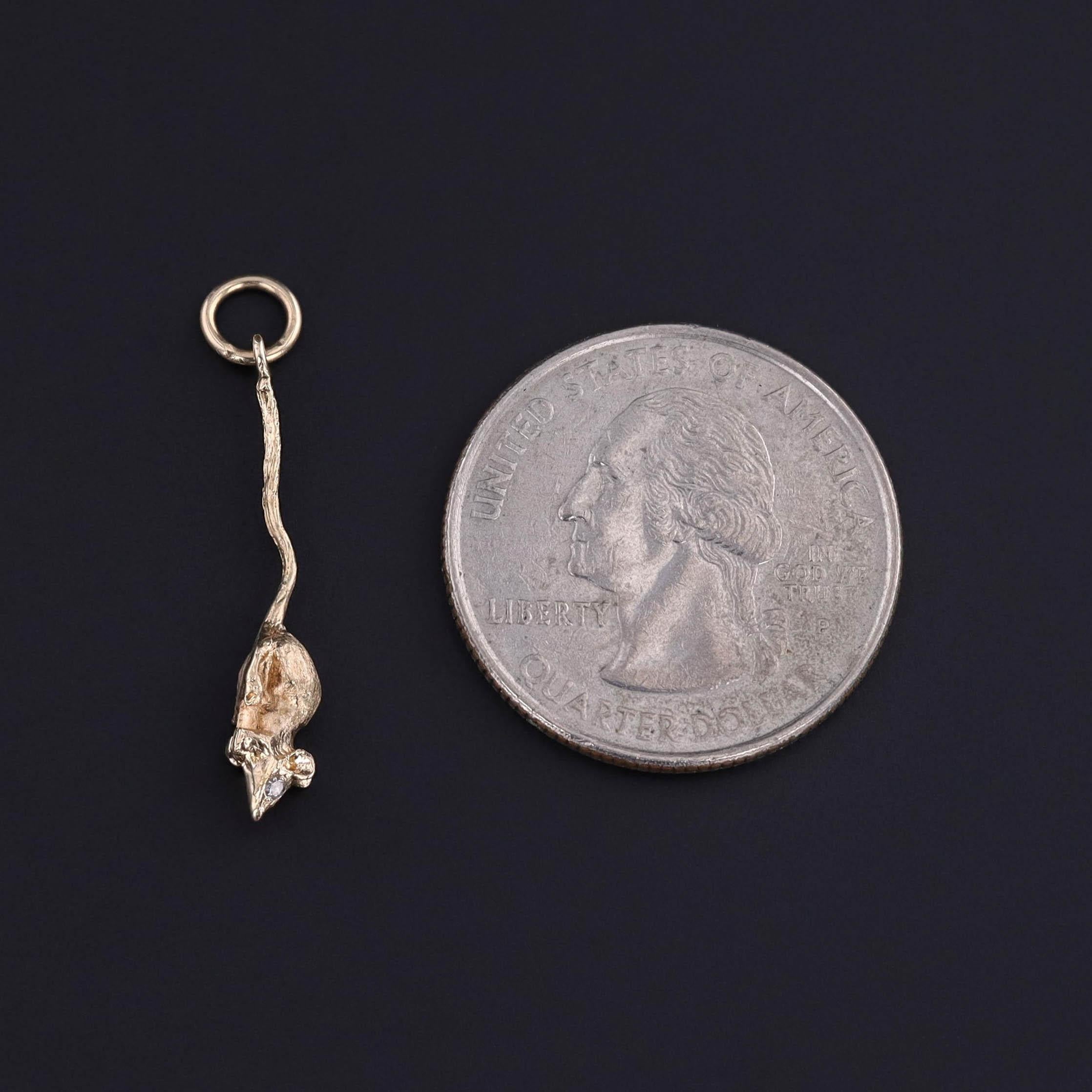 A vintage mouse charm of 14k gold with two diamond eyes, dating to 1930.

The piece measures 1.2 inches from the top of the jump ring to bottom by 0.2 inches wide and weighs 1.17 grams. It is in great condition.

The metal content of this charm was